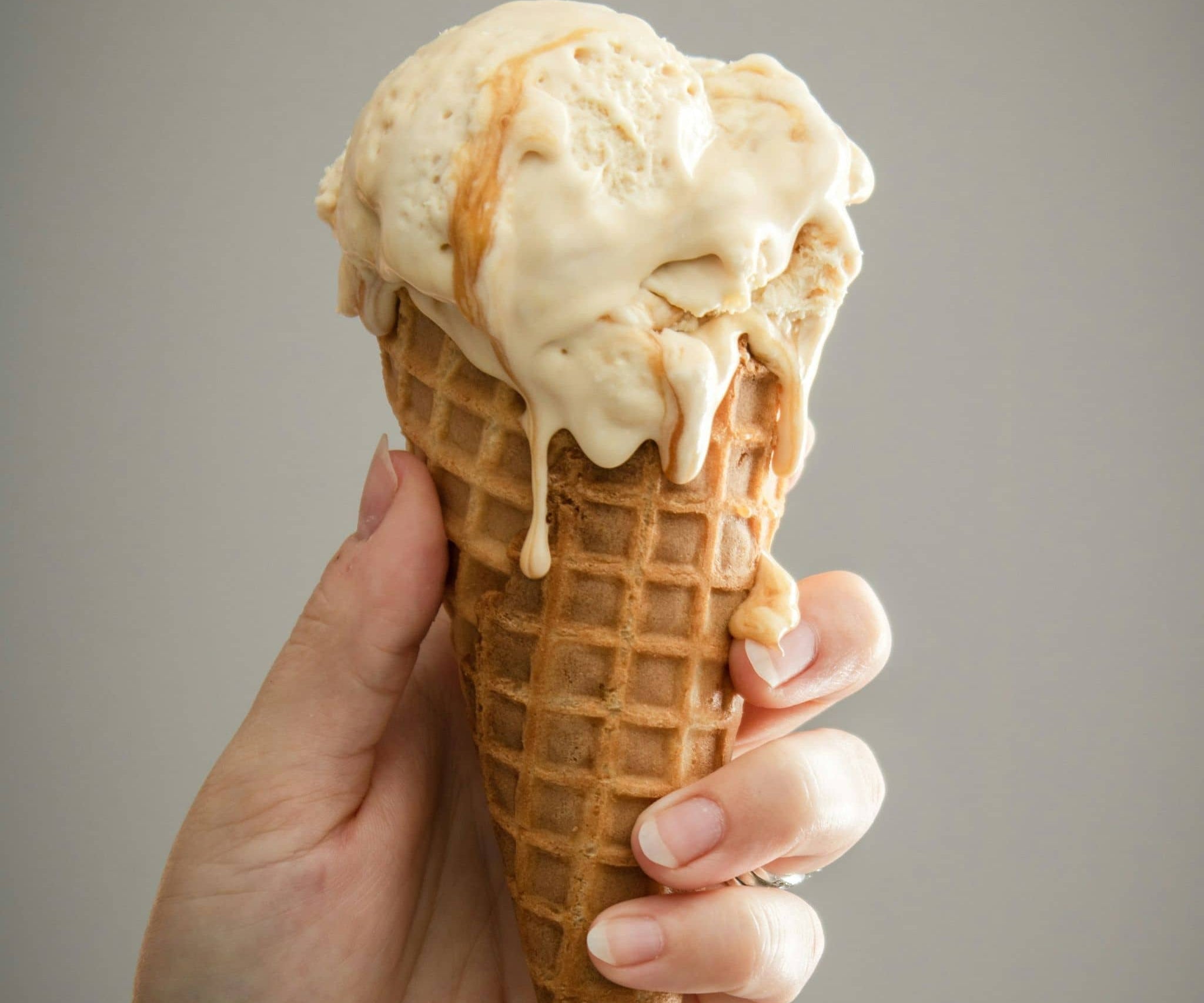 Hand holding Vanilla Caramel ice cream cone