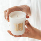 Hands holding Caitlin Louise Collection Signature range scented mini candle with white background