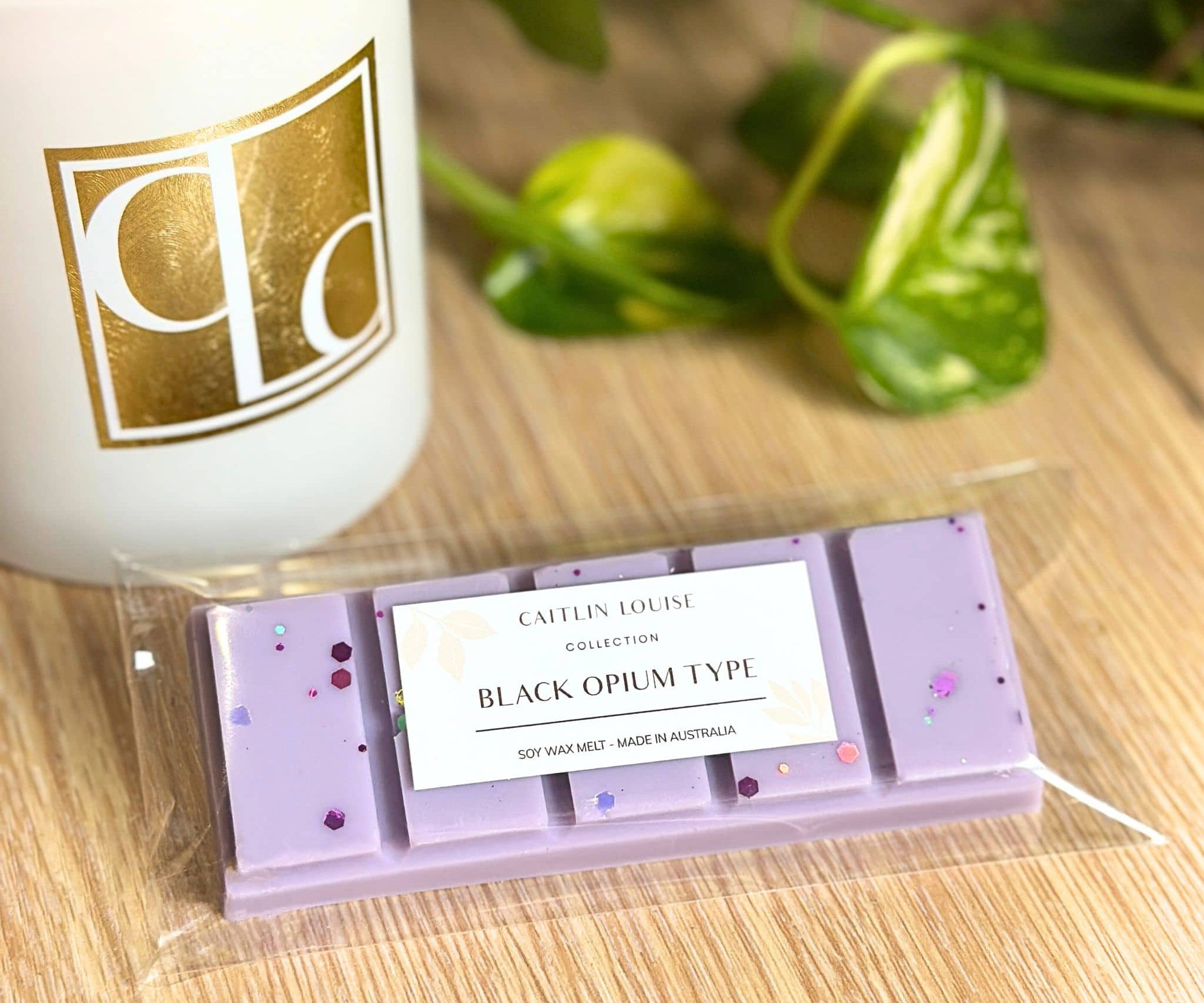 Black Opium Type wax melt snap bar in packaging with candle