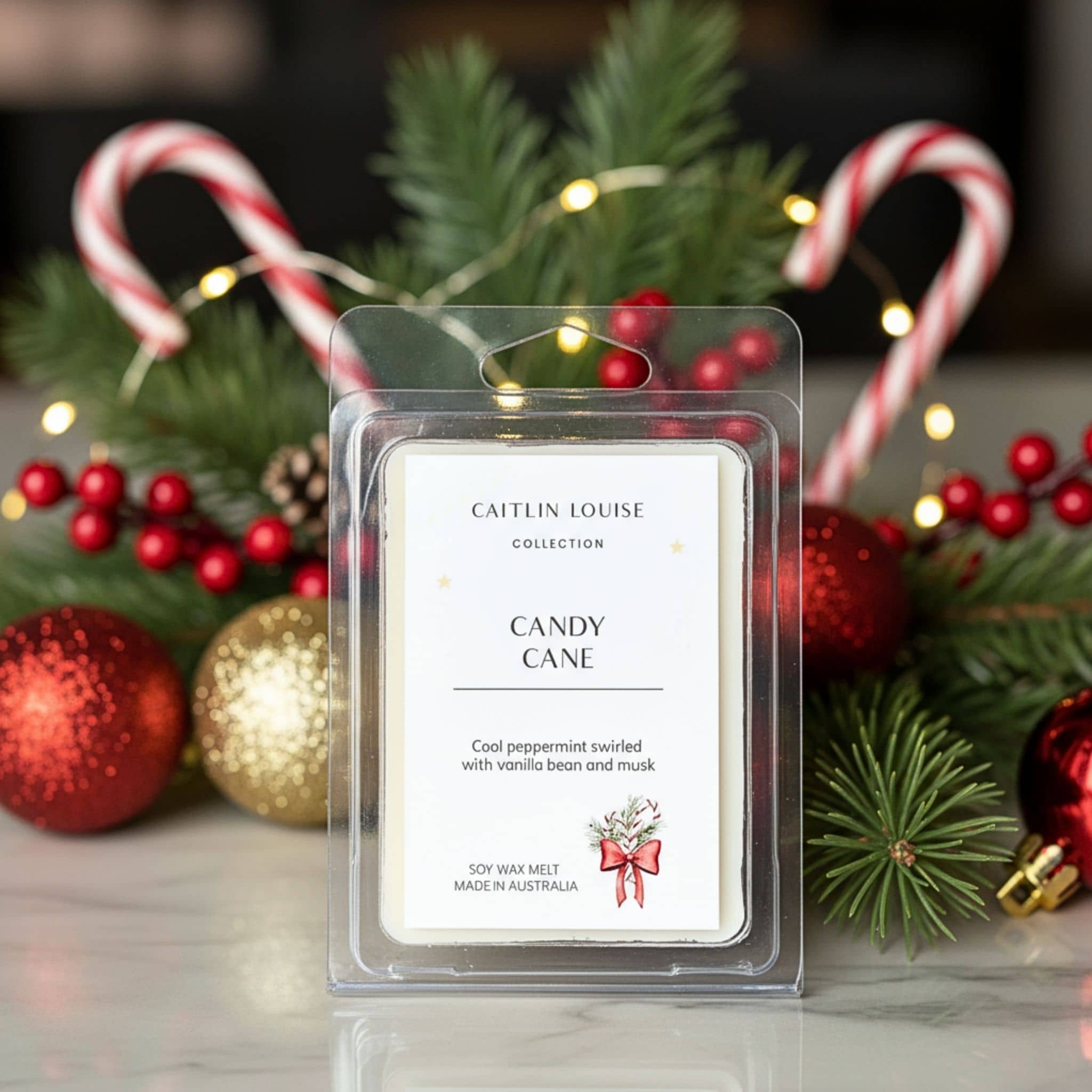 Candle wax melt package labeled 'Candy Cane' by Caitlin Louise Collection, surrounded by Christmas decorations.