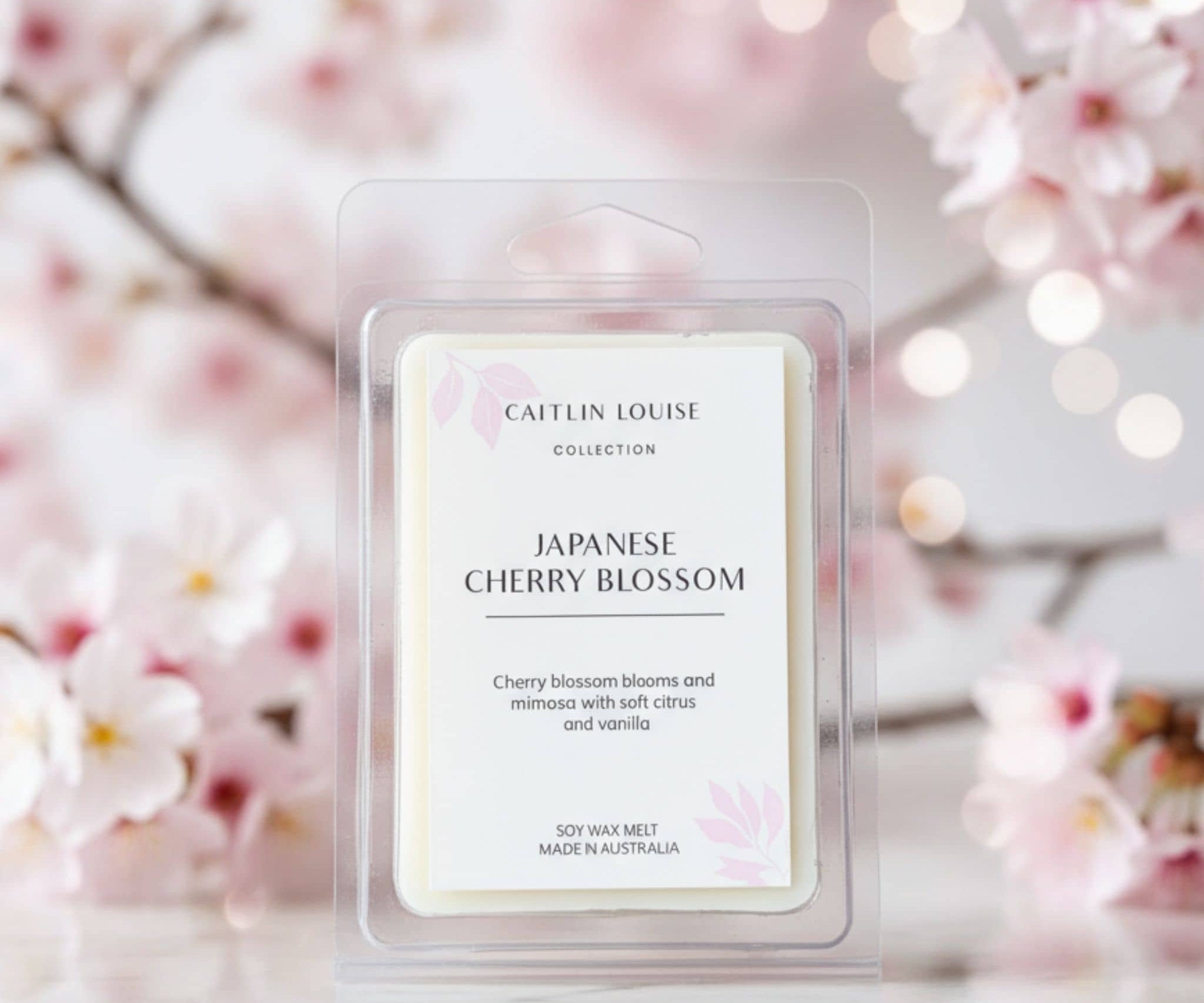 Japanese Cherry Blossom wax melt packaging with cherry blossoms in background