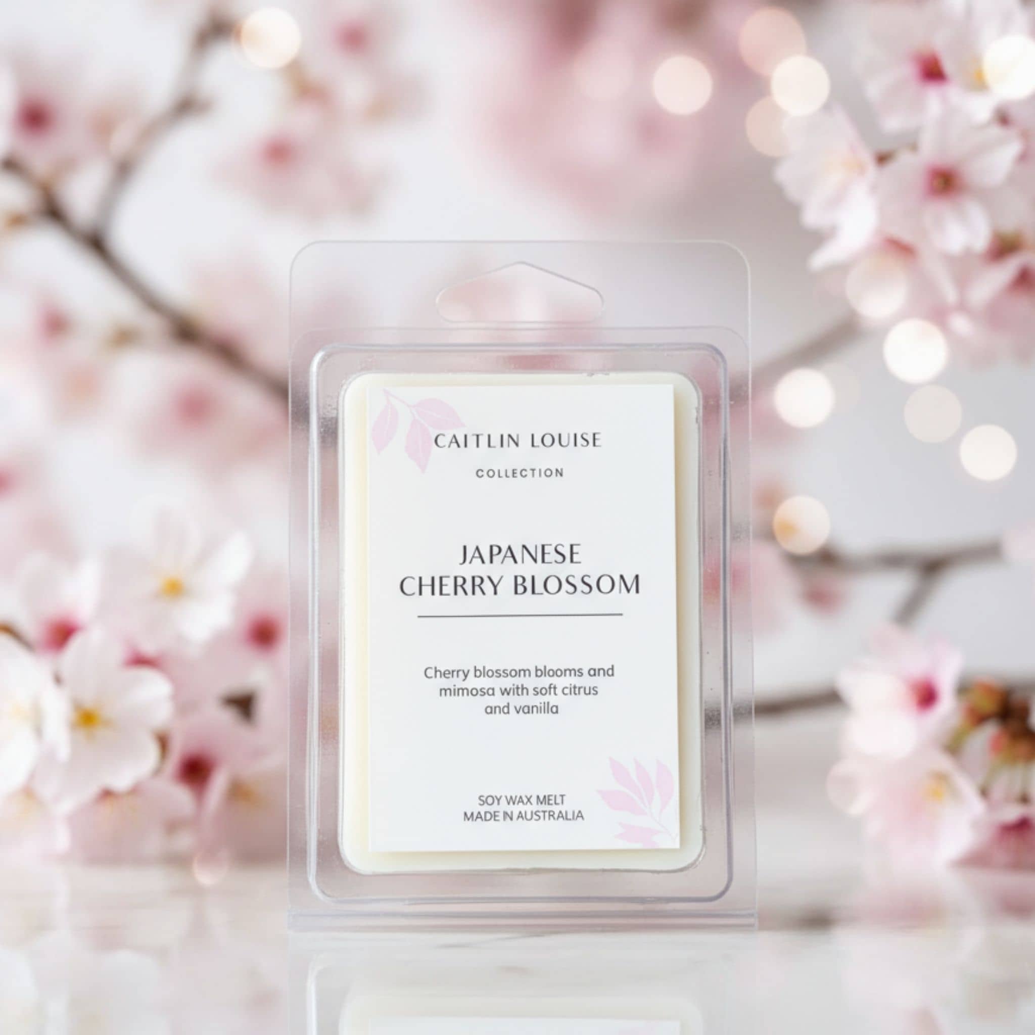 Japanese Cherry Blossom wax melt packaging with cherry blossoms in background