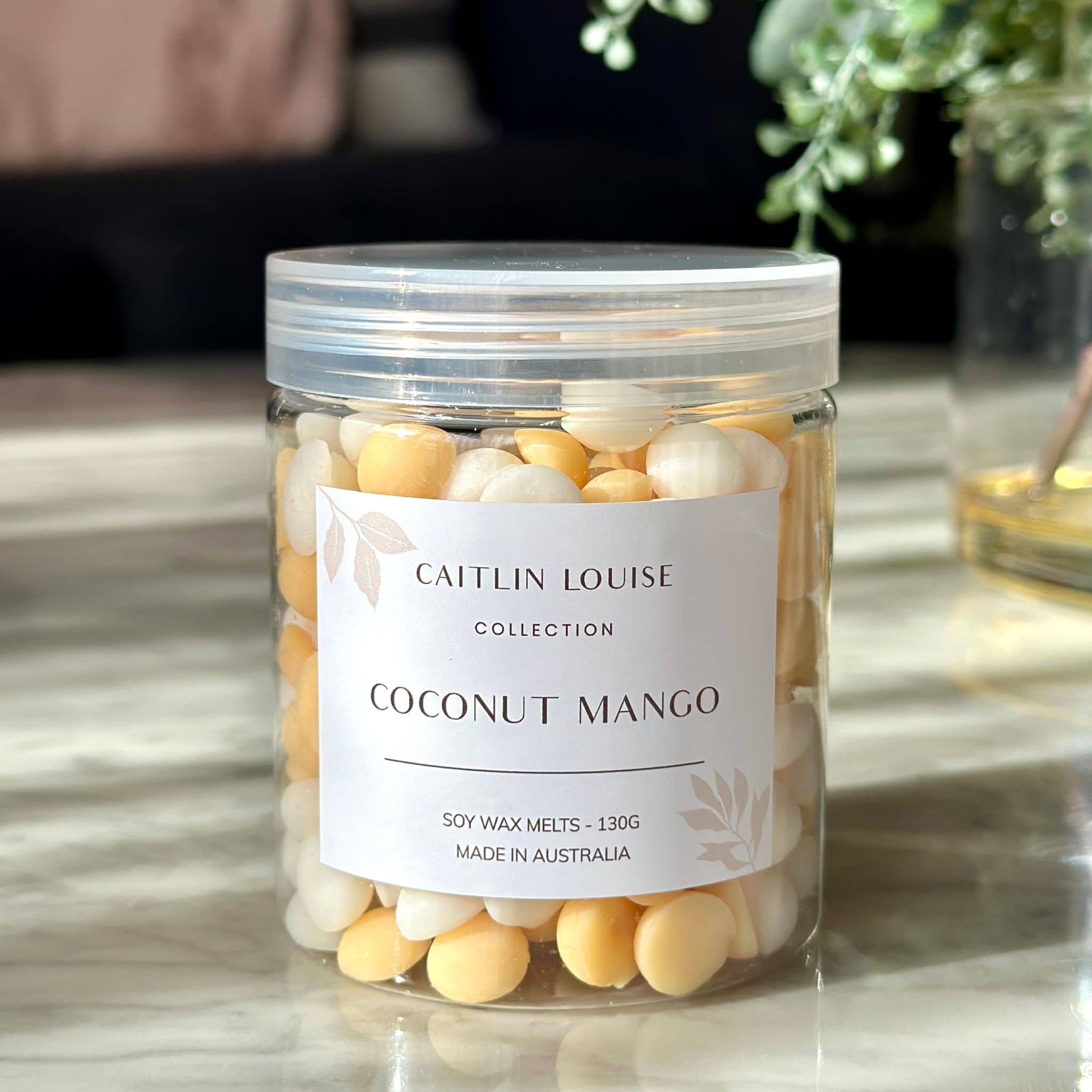 Caitlin Louise Collection's Coconut Mango Soy Wax Melt Pebbles - on coffee table.