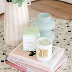 Lime in Paradise crystal infused candle on stack of books on coffee table