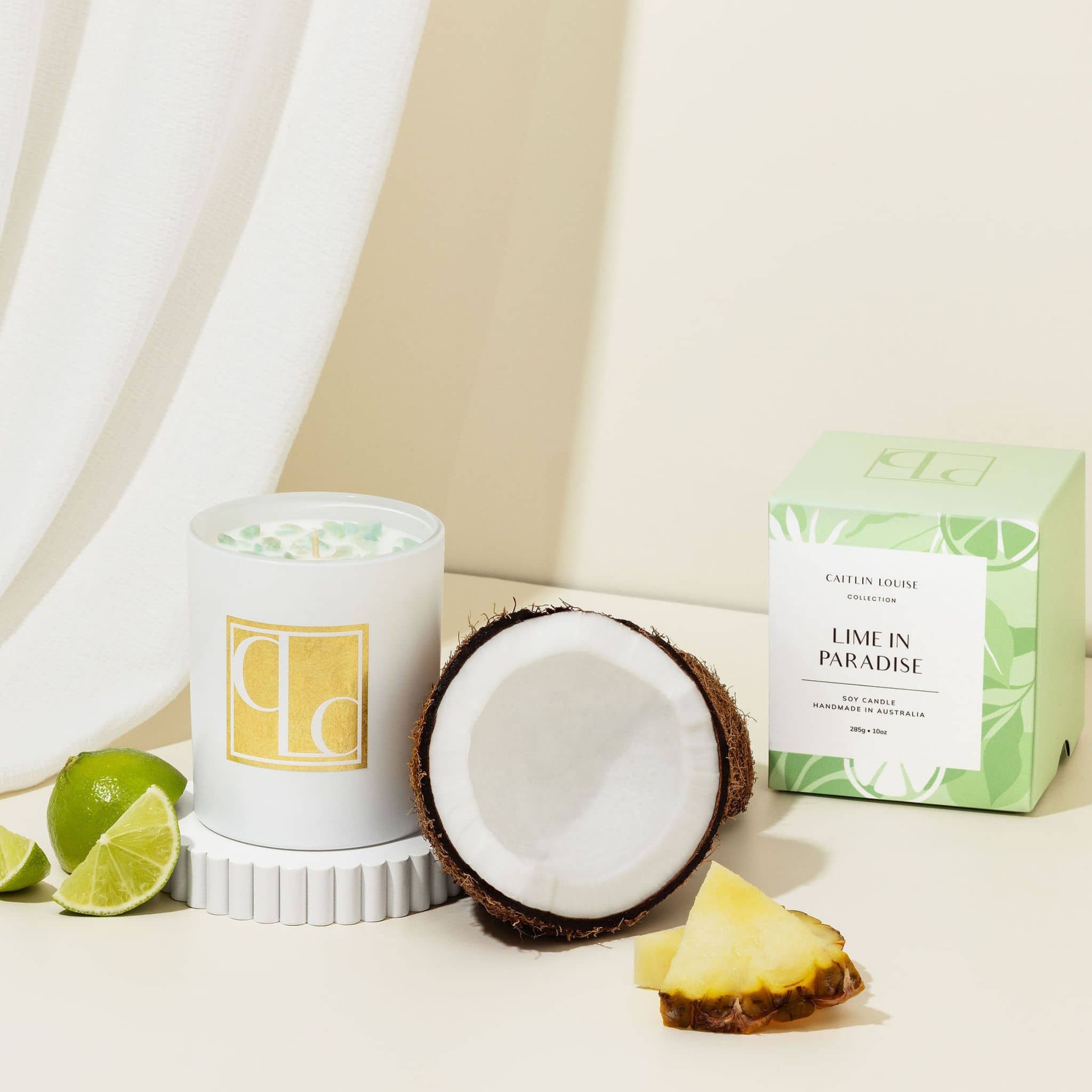 Lime coconut Candle with fresh coconut and pineapple on a neutral background