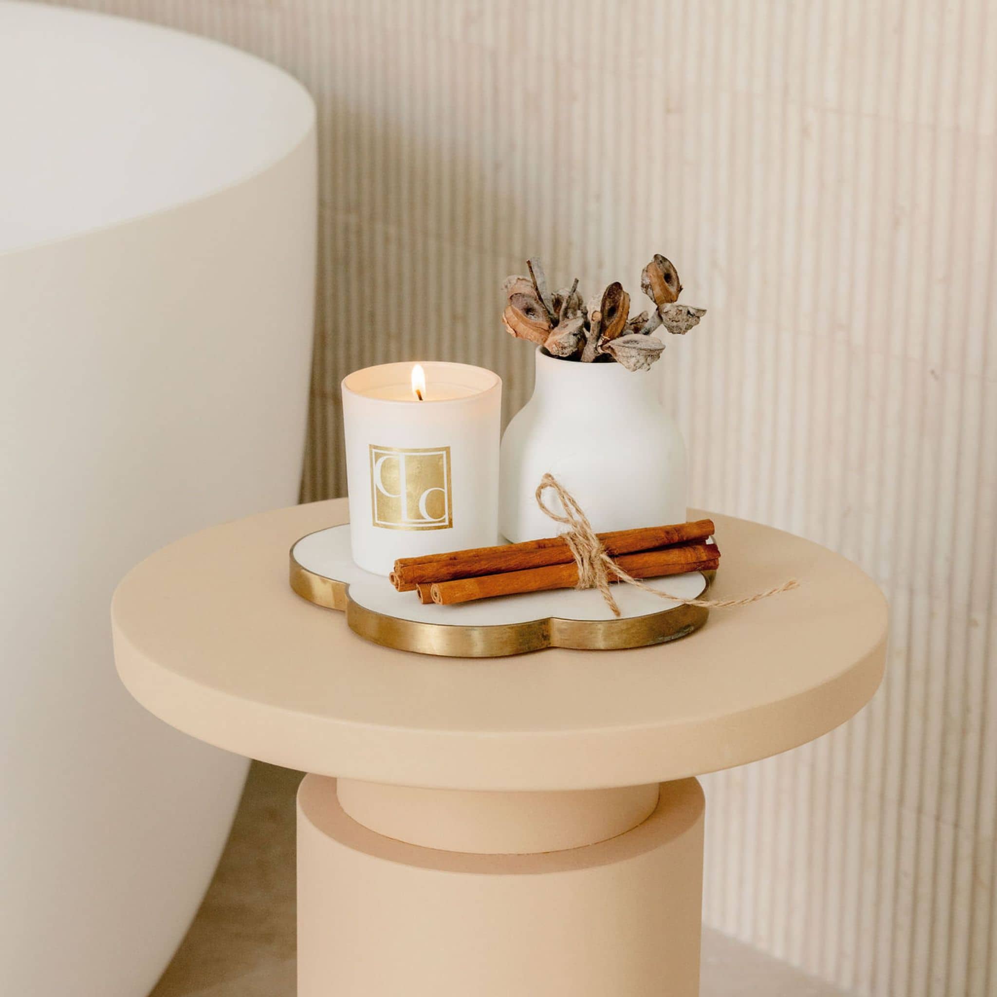 CLC lit candle on bathroom bench with dried flowers