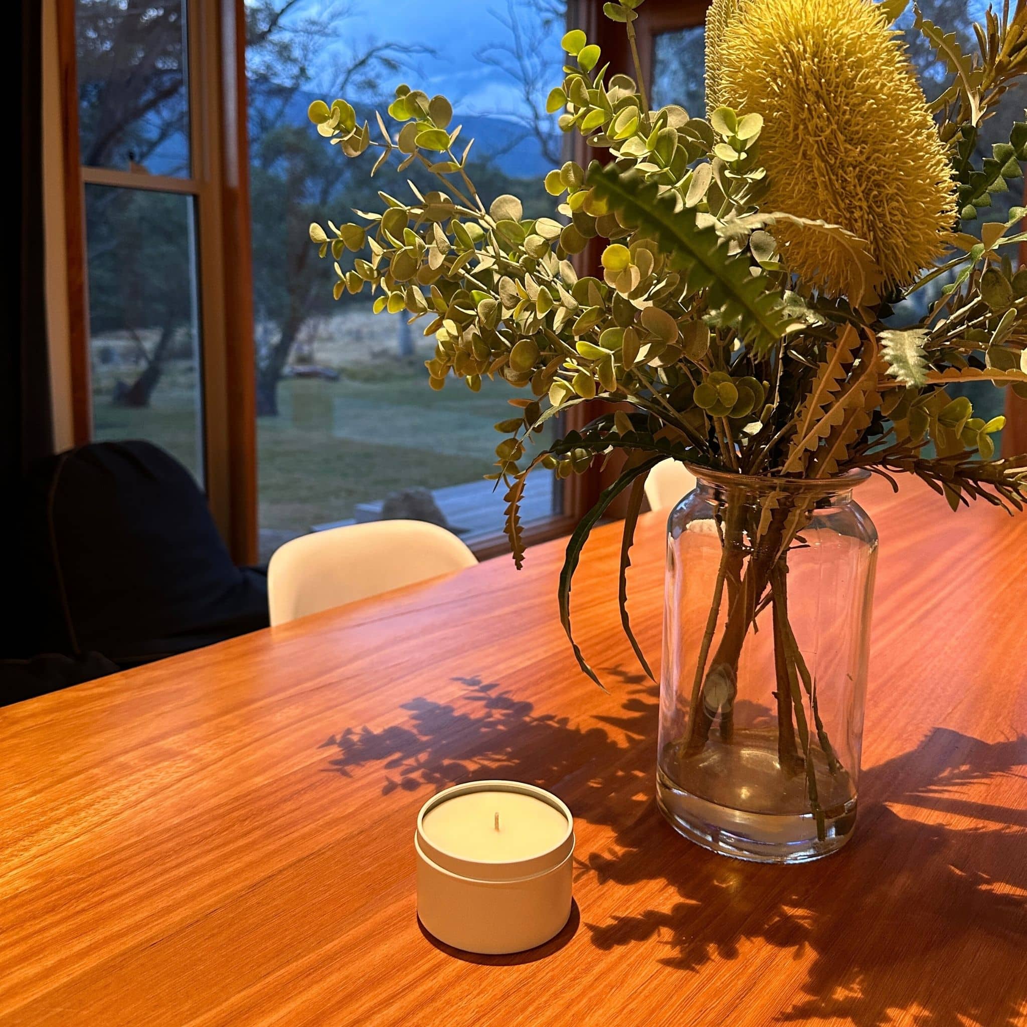 Travel candle styled on dining table in holiday house.