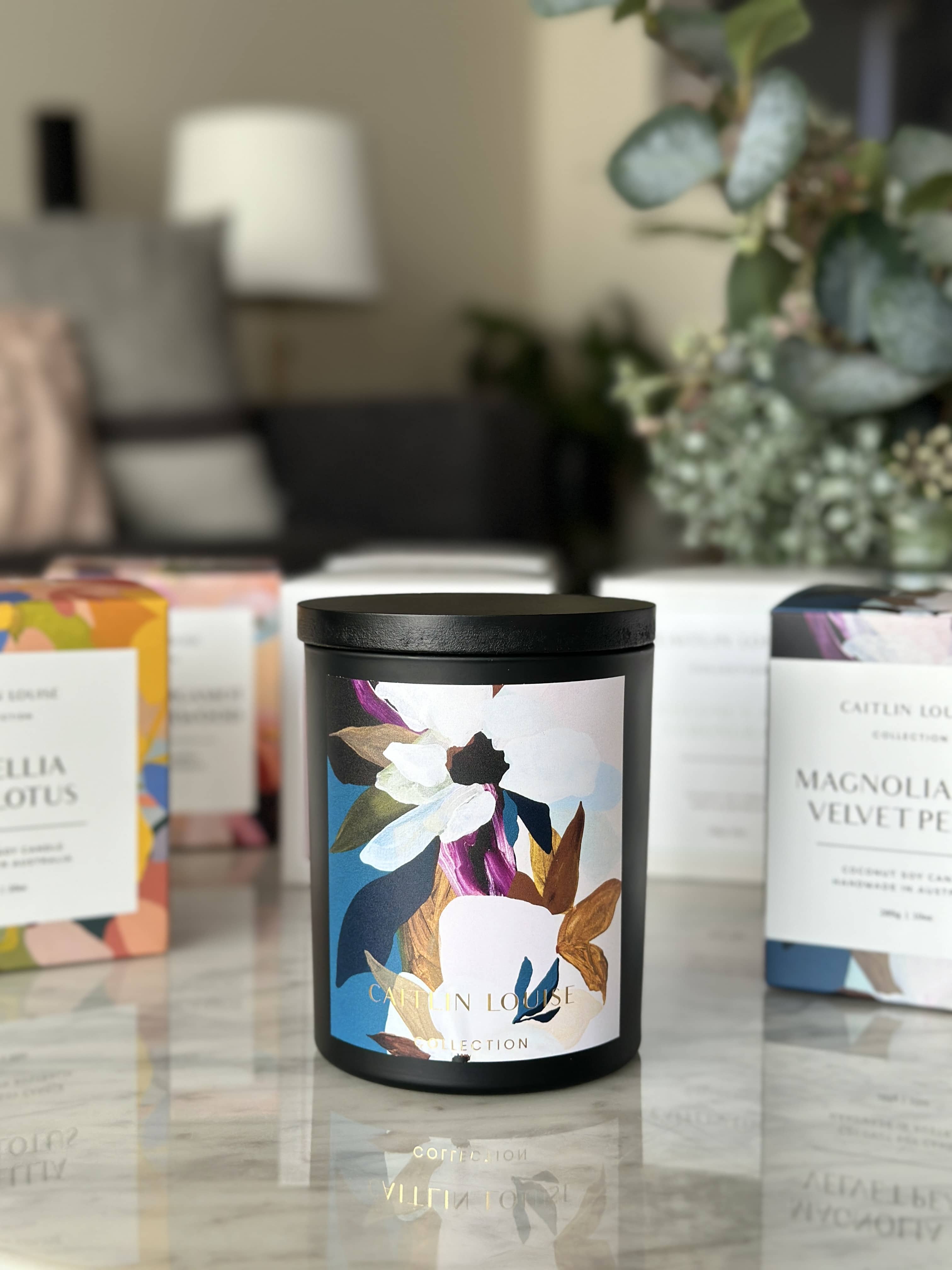 Caitlin Louise Collection Magnolia and Velvet Peach candle on coffee table