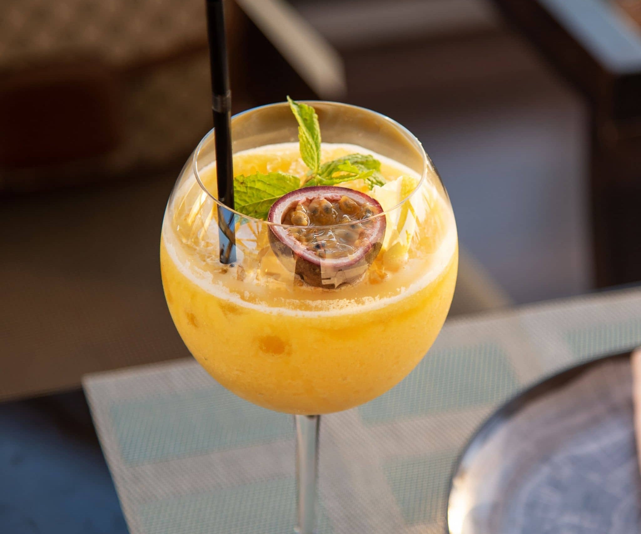 Passionfruit cocktail in a glass with a straw