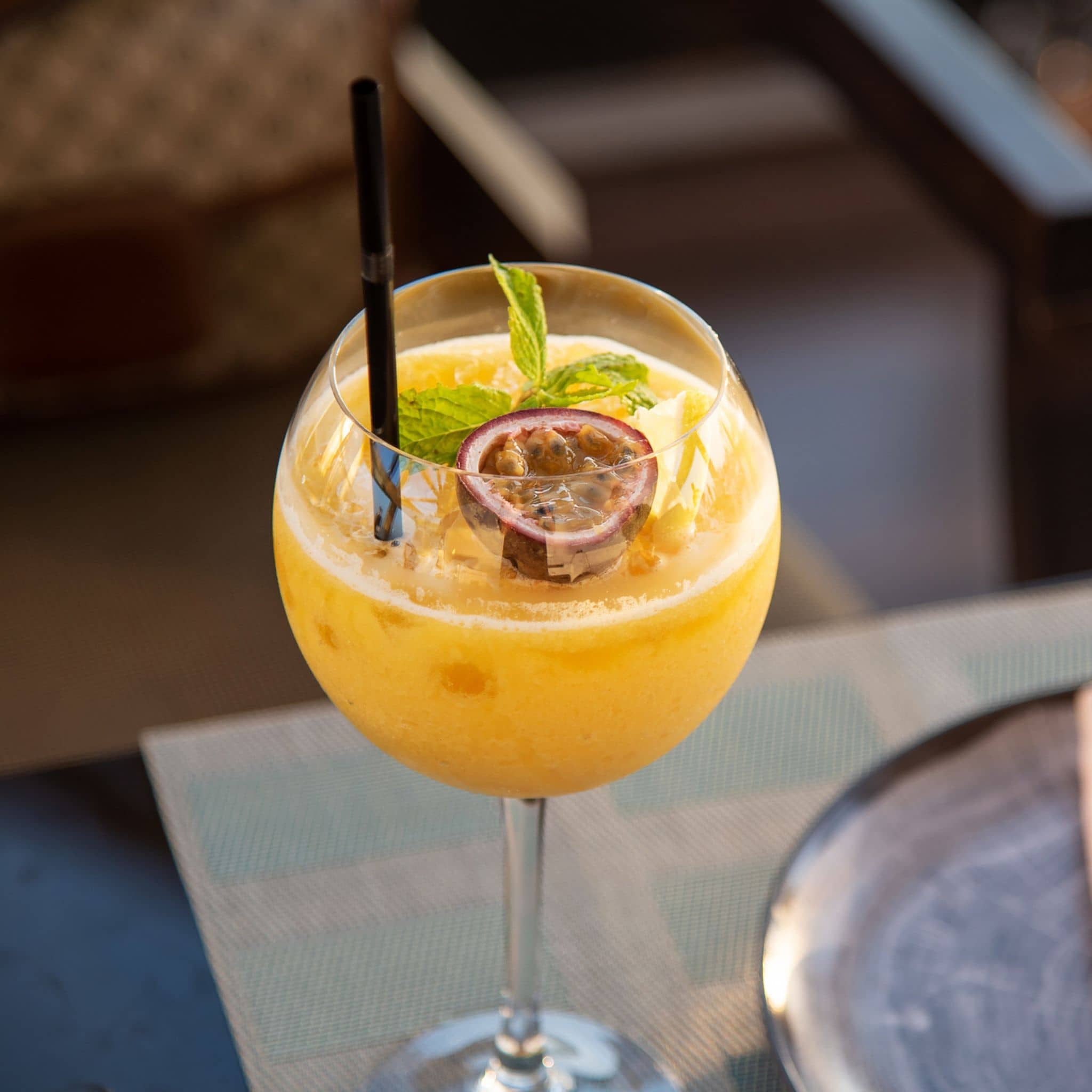 Passionfruit cocktail in a glass with a straw