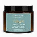 Amber glass jar candle with a black lid and a dusty teal label that reads 'CAITLIN LOUISE COLLECTION' and 'TOO MANY BOOKS? YOU MEAN NOT ENOUGH SHELVES'.