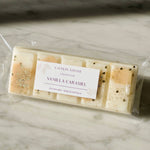 Close up of Caitlin Louise Collection's Vanilla Caramel Soy Wax Melt Snap Bar in packaging on marble table.