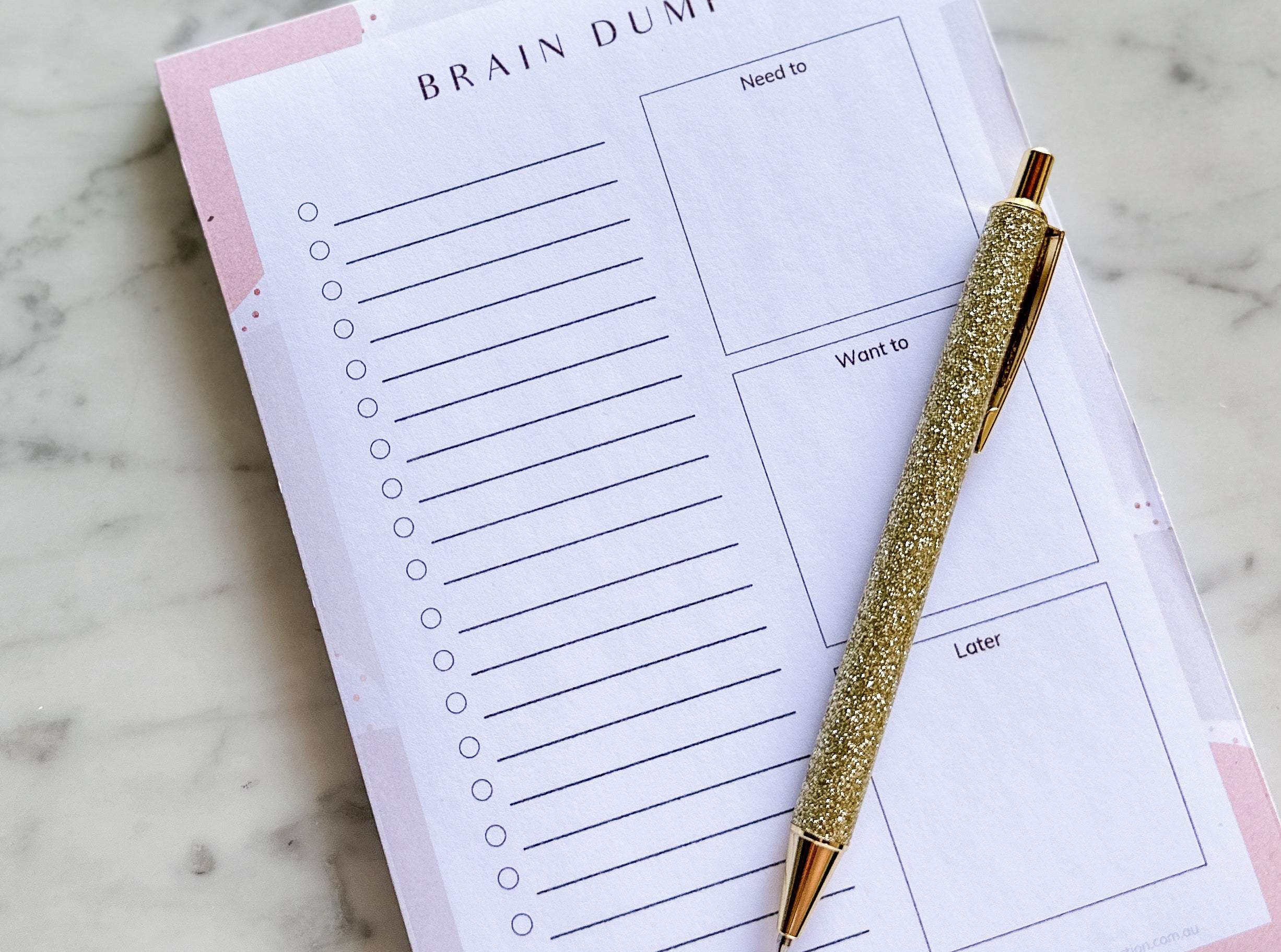 Brain dump notepad for self-care organisation styled on coffee table and pen.