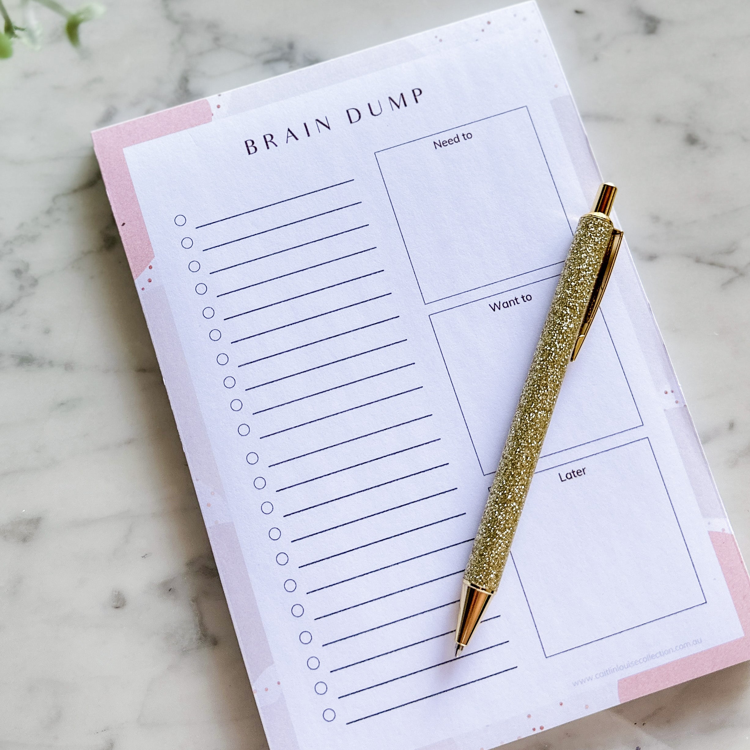 Brain dump notepad for self-care organisation styled on coffee table and pen.
