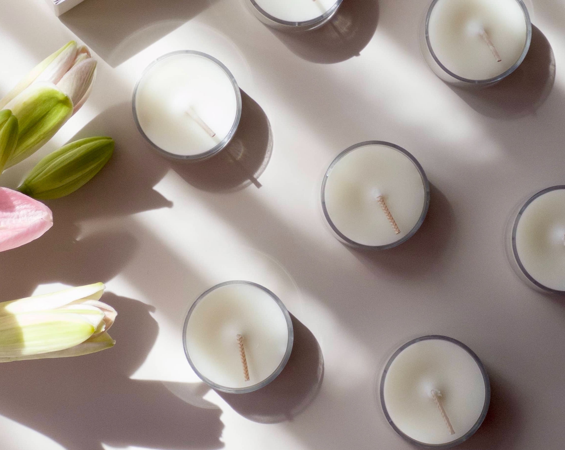 Close up of flat lay photo of sample scent tealight candles - flowers to the side.