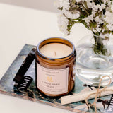 Caitlin Louise Collection A Midsummer Night Bookish Candle - styled on book with scroll and flowers