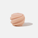 Apricot coloured spiral shaped candle - white background