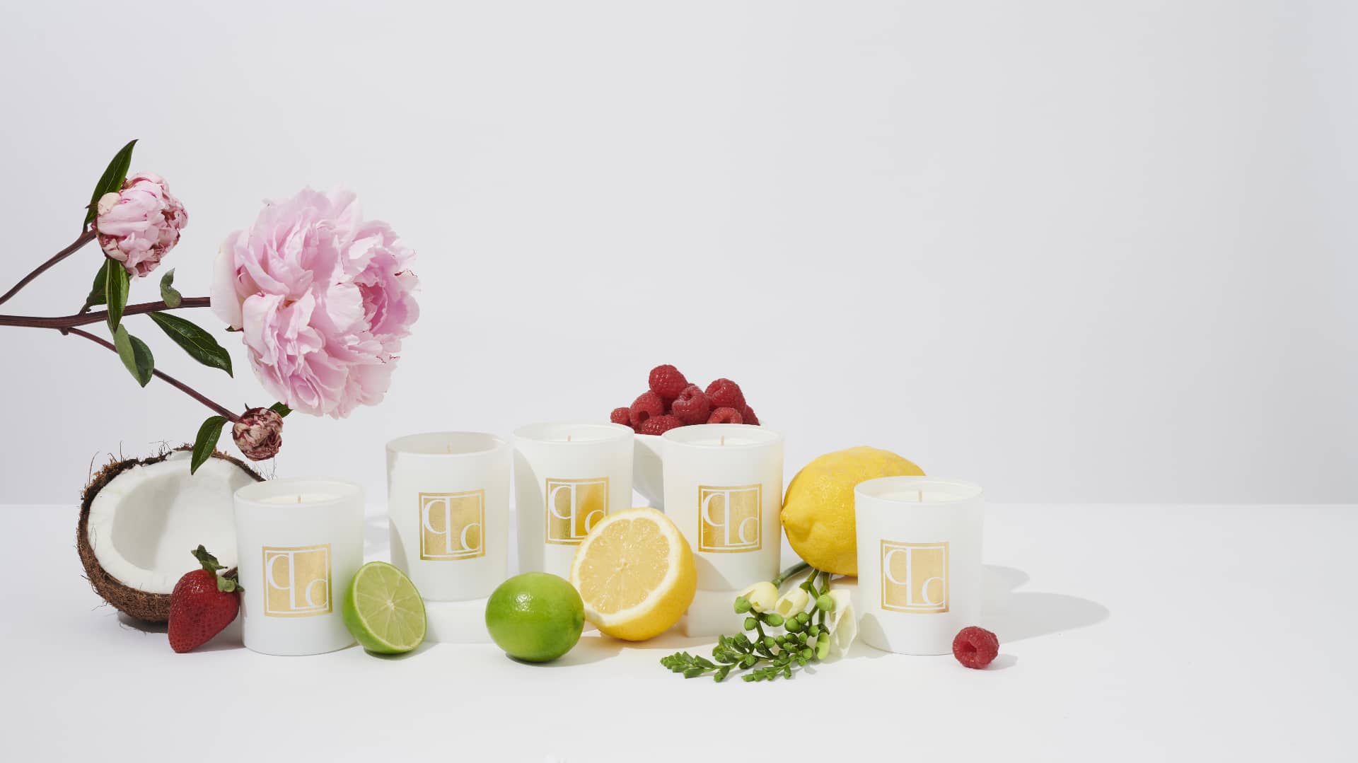 Mini scented candle collection with white background surrounded by fruit and flowers