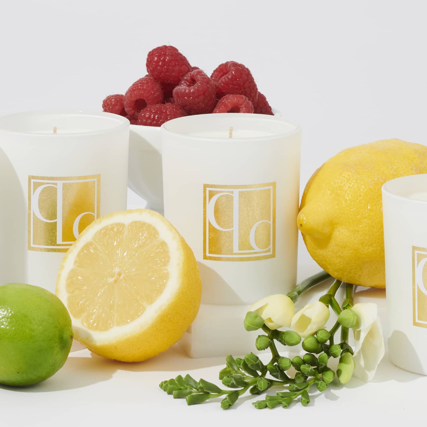 Mini scentd candles styled with fruit on white background