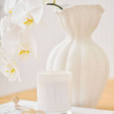 Caitlin Louise Collection Core Candle styled with wick trimmers and vase of flowers