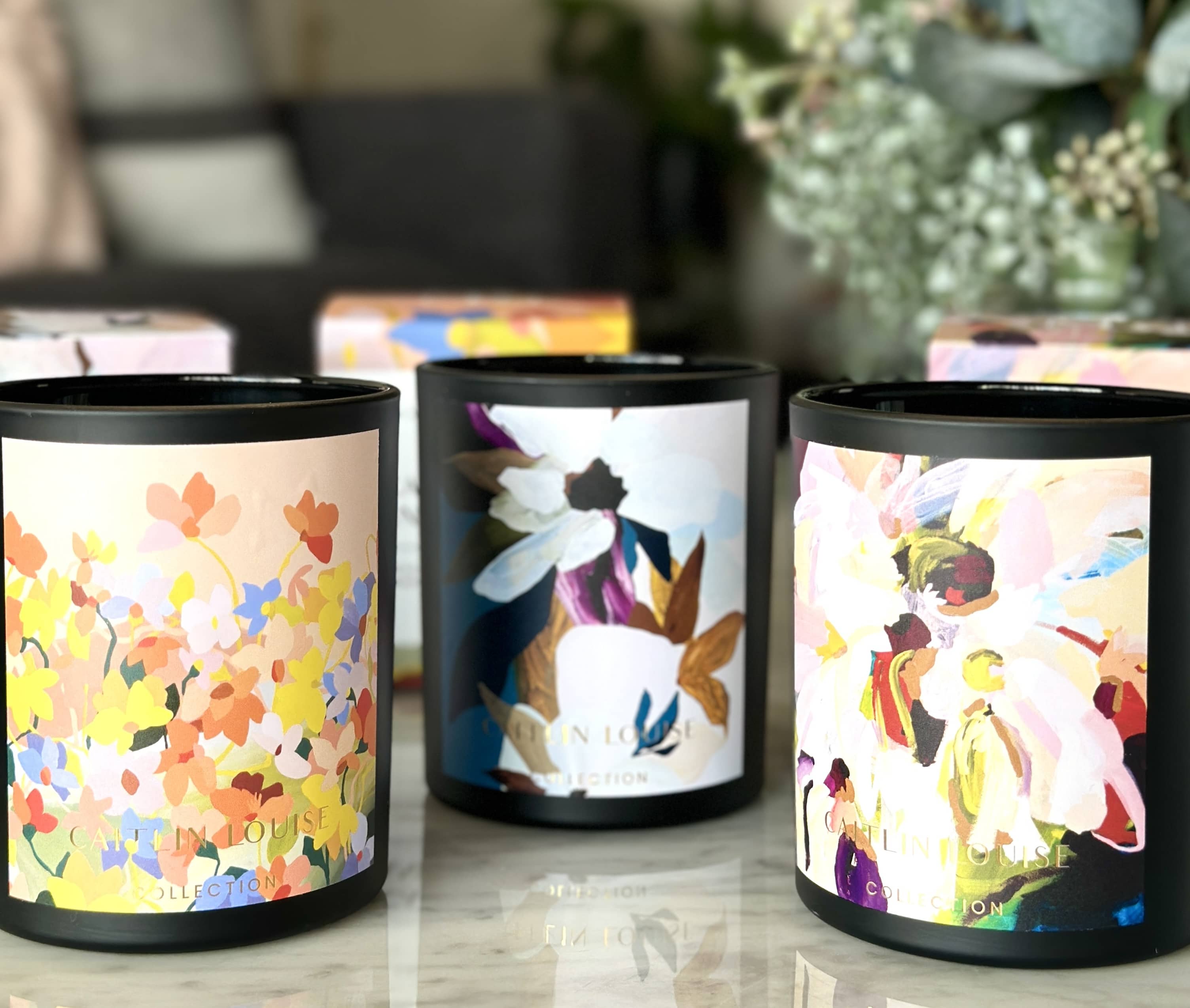 Caitlin Louise Collection Artist Candles on coffee table - Prudence De Marchi artwork.