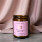 Candle jar with a pink label on a neutral background