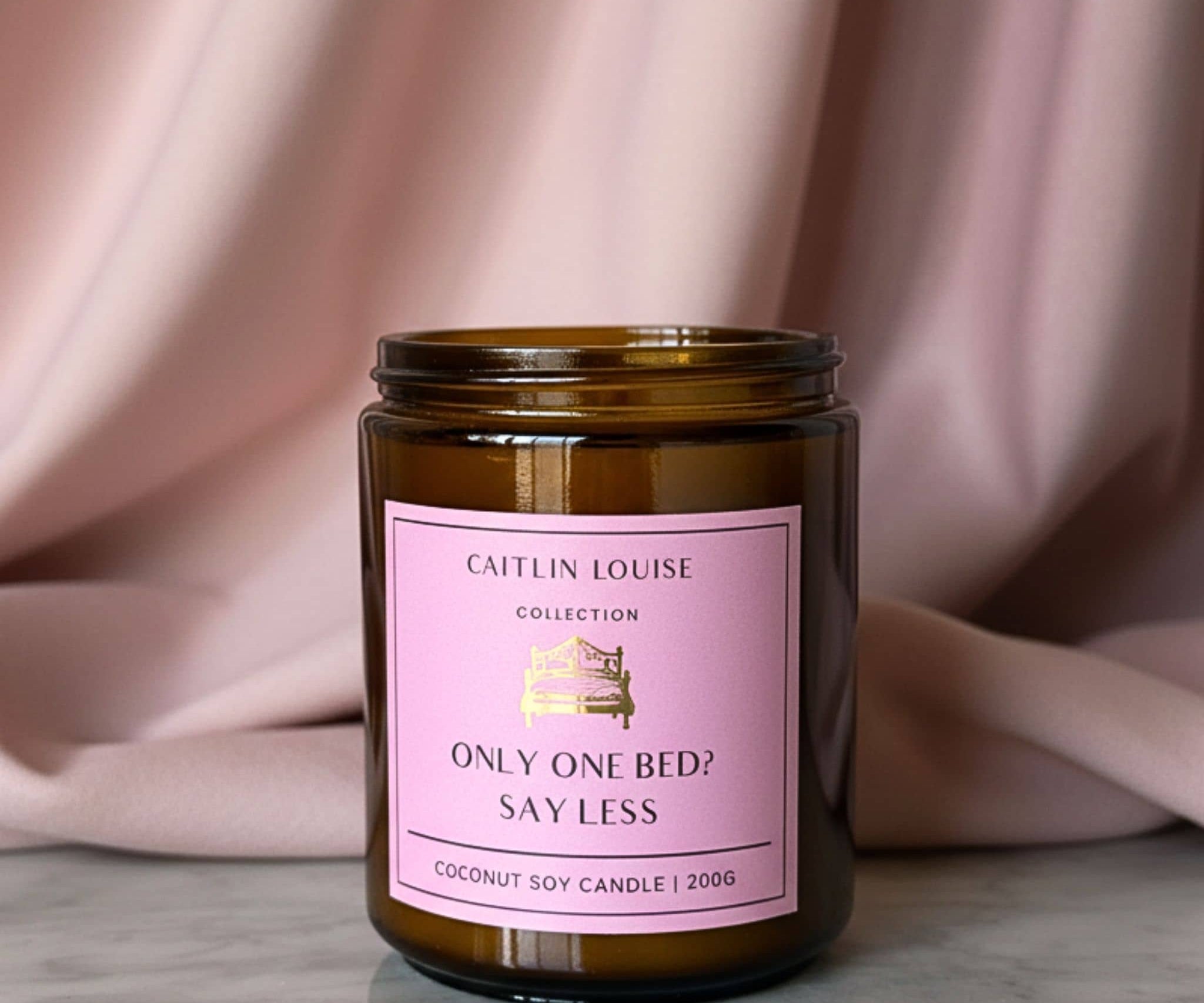 Candle jar with a pink label on a neutral background