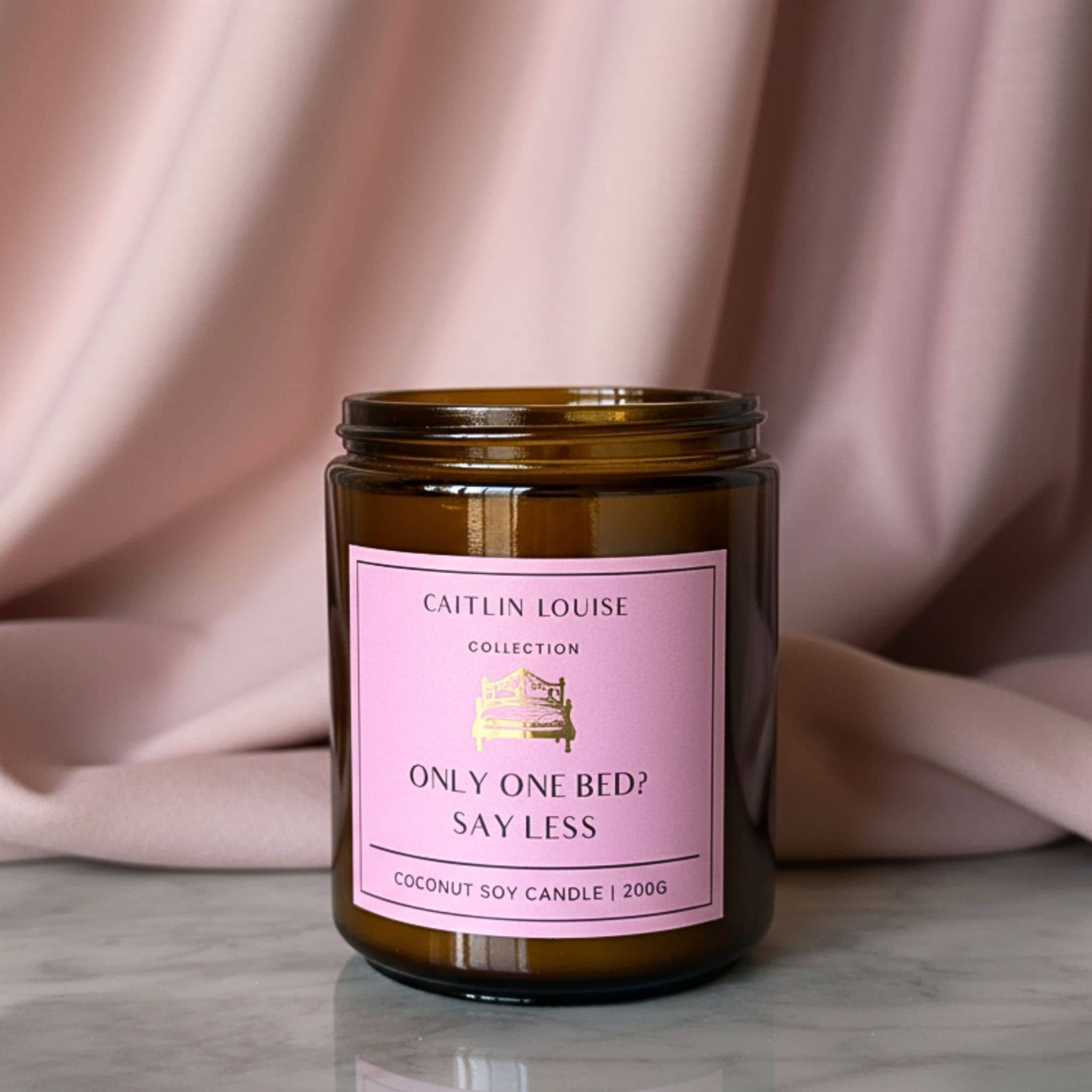 Candle jar with a pink label on a neutral background