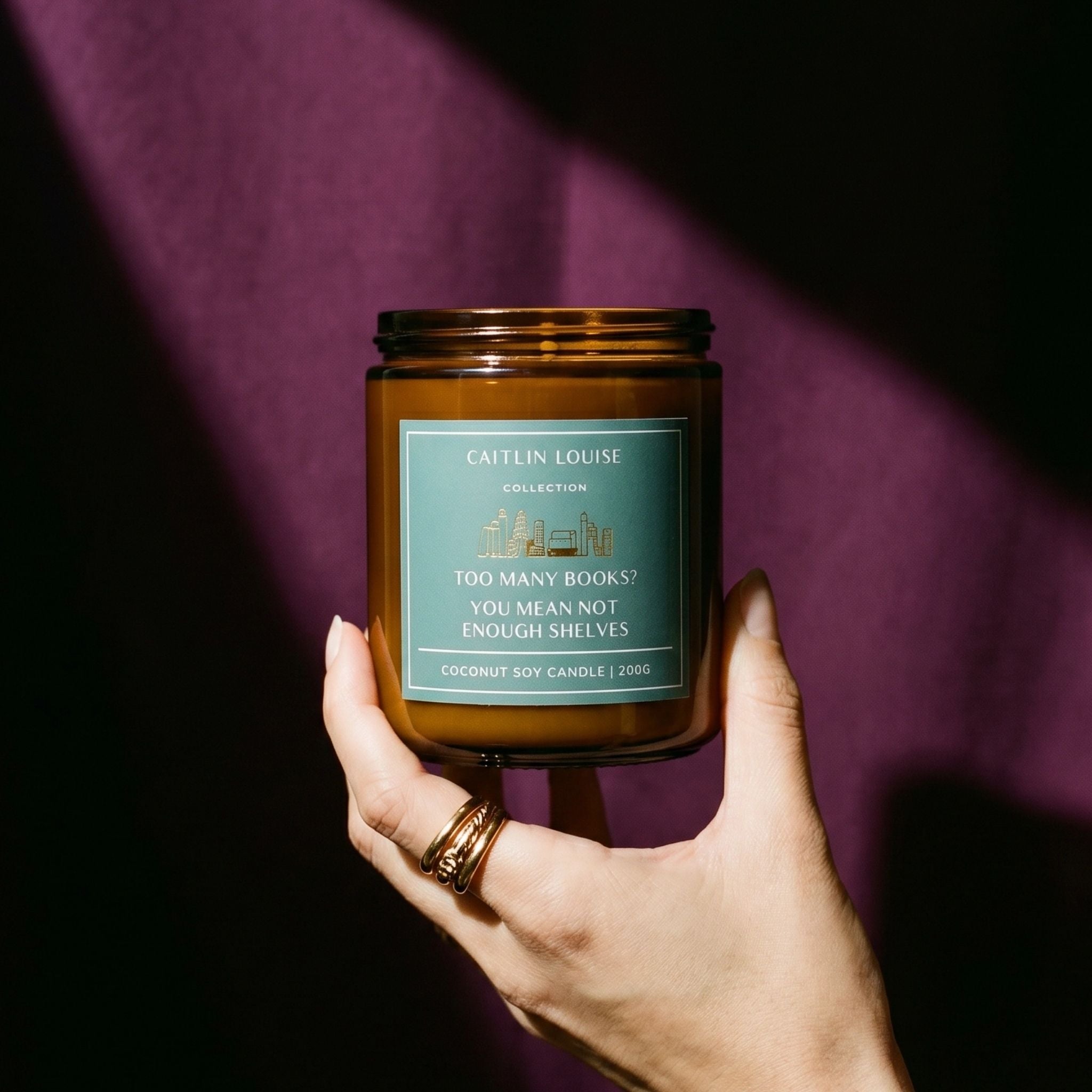 Bookish candle held in hand on purple background