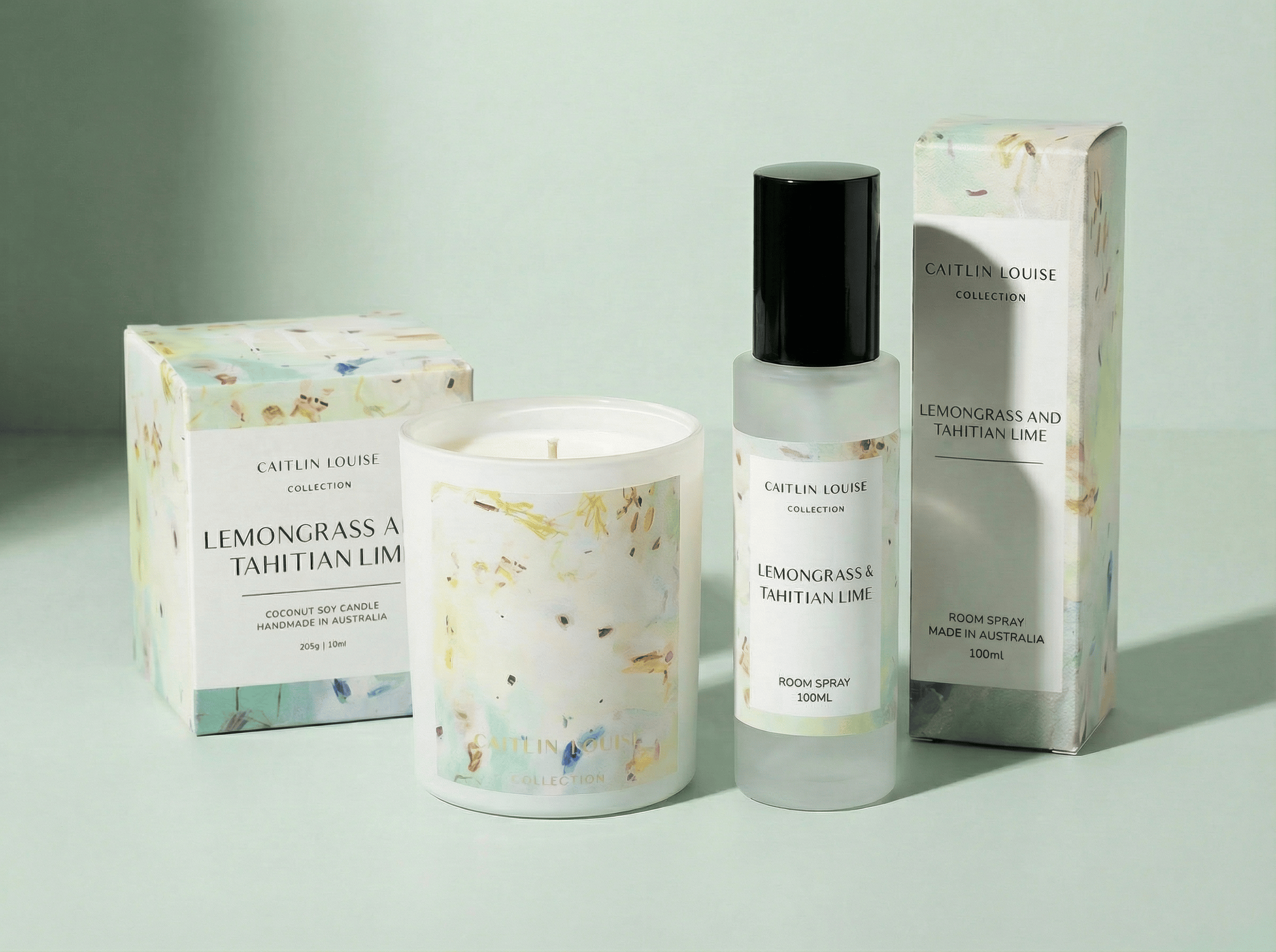 Candle, bottle, and packaging with 'Caitlin Louise' branding on a light background