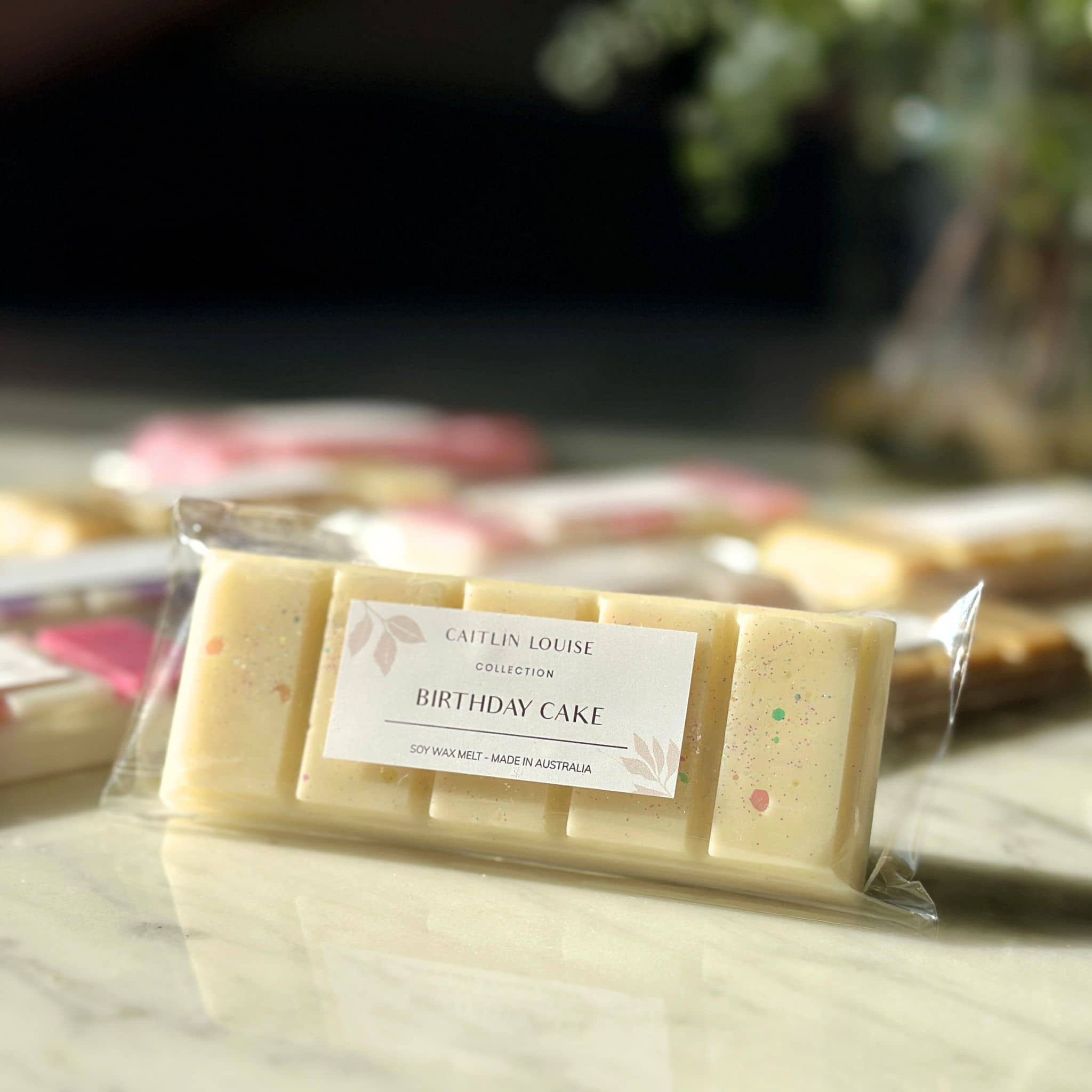 Close up of Caitlin Louise Collection's Birthday Cake scented soy wax melt snap bar on coffee table.