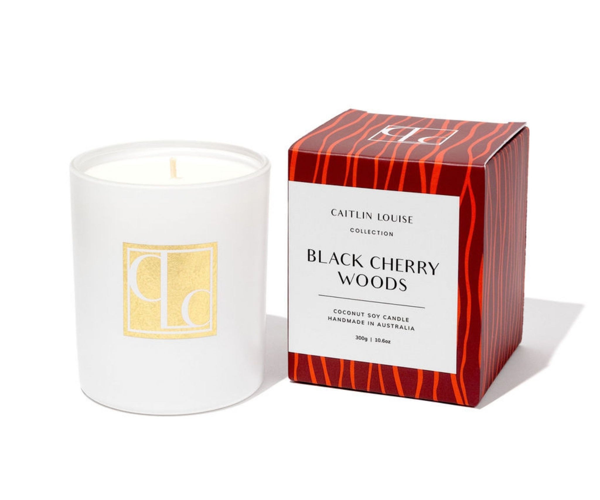 White candle with a red and maroon box labeled 'Black Cherry Woods' on a white background