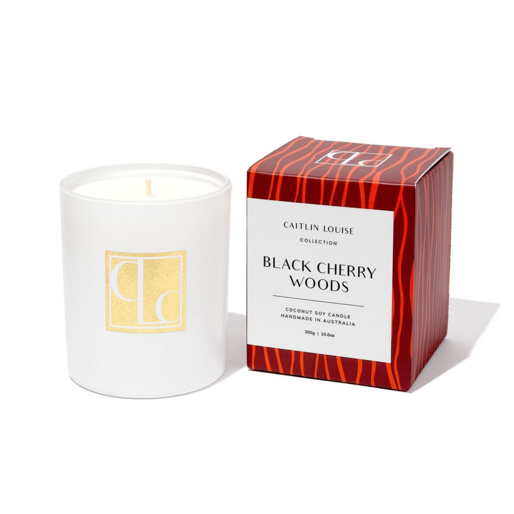 White candle with a red and maroon box labeled 'Black Cherry Woods' on a white background