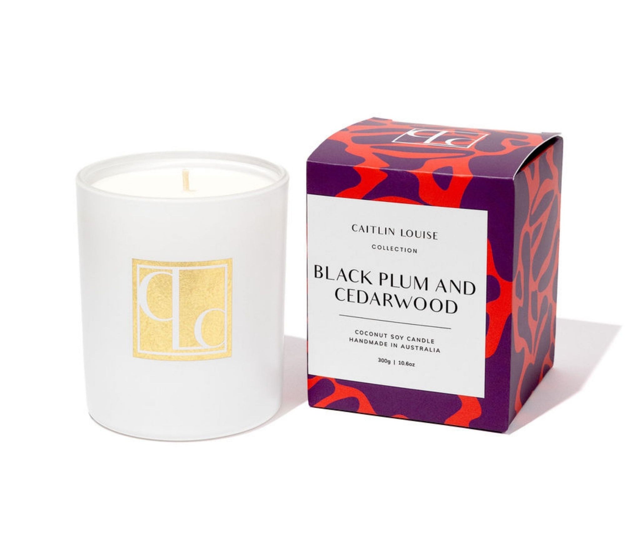 Caitlin Louise Collection white candle with a decorative box labeled 'Black Plum and Cedarwood' on a white background