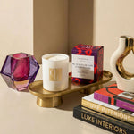 Candle with a decorative box and books on a table