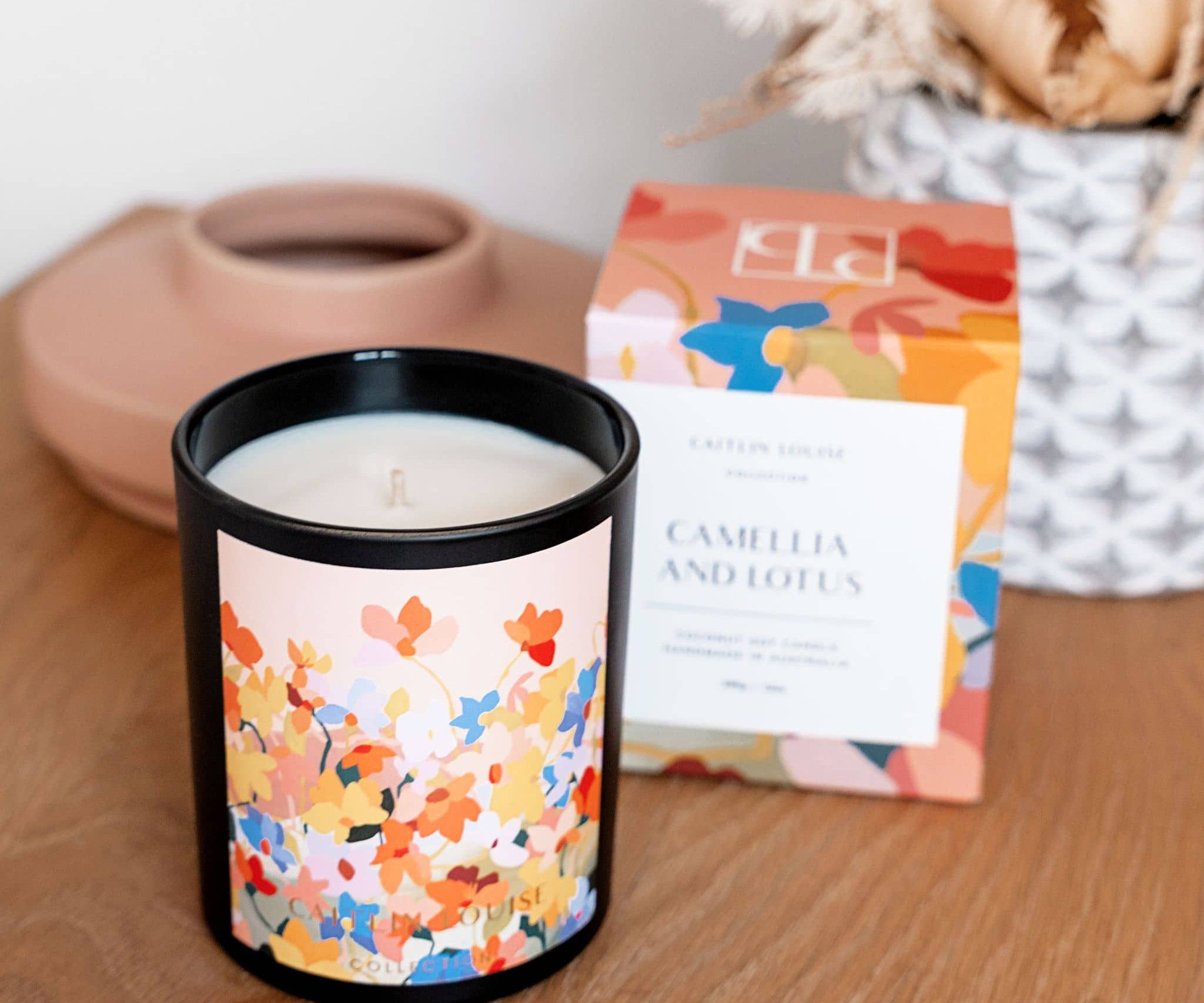 Caitlin Louise Collection Camellia and Lotus Artist Candle on table with candle box behind