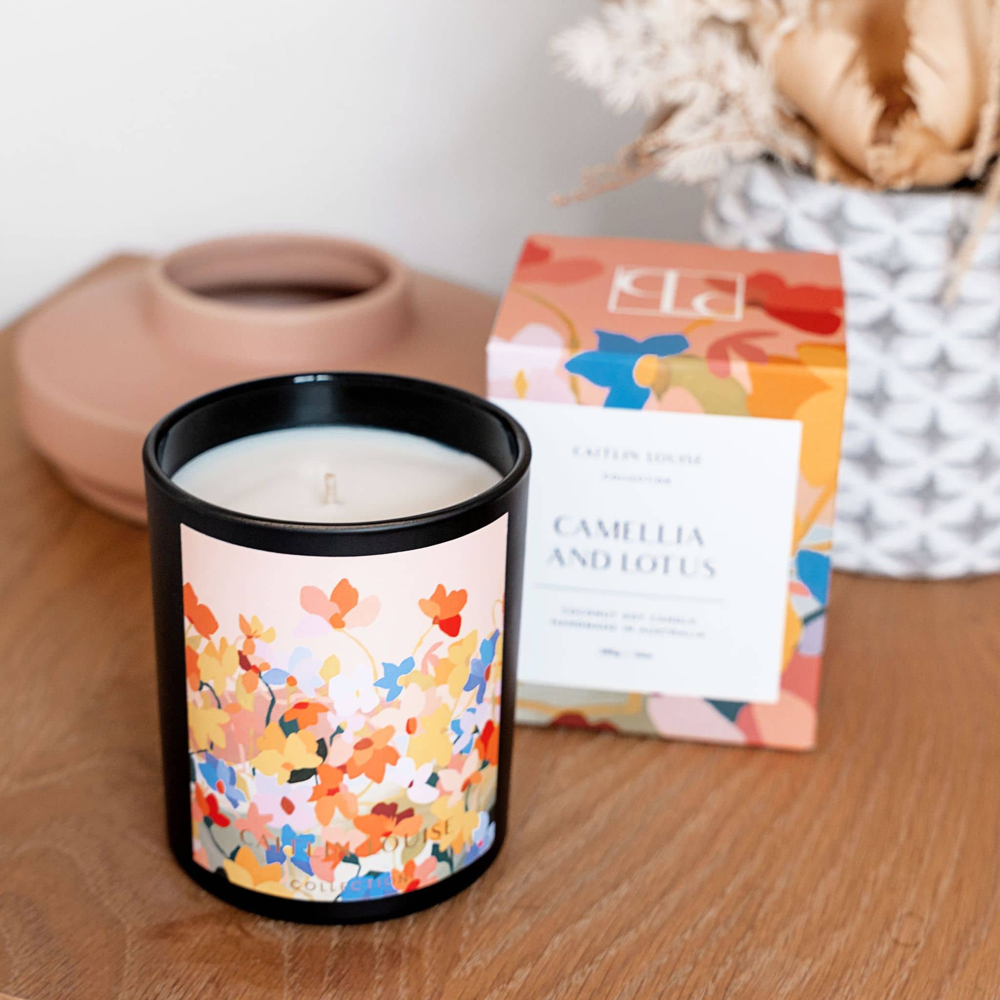 Caitlin Louise Collection Camellia and Lotus Artist Candle on table with candle box behind