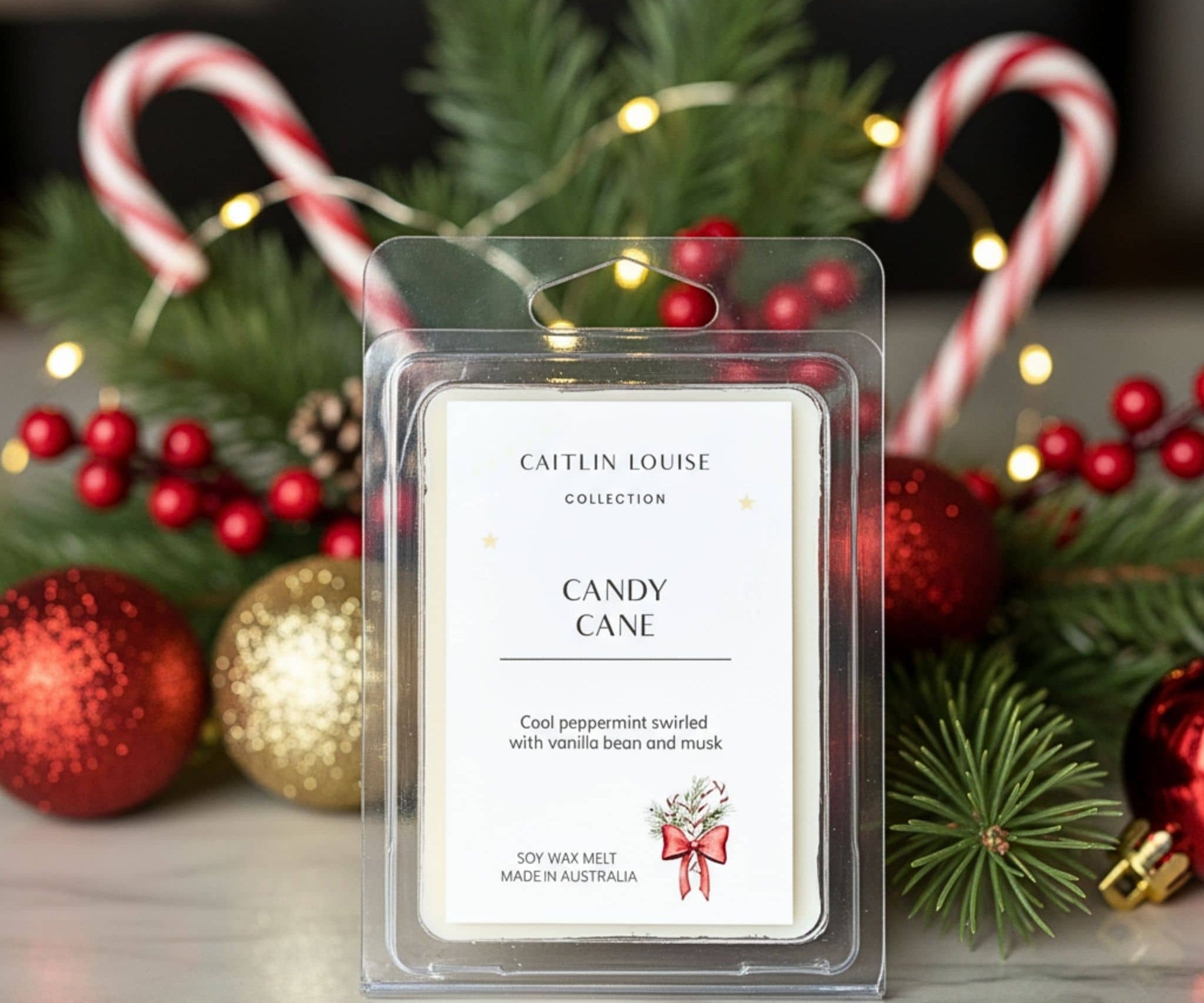 Candle wax melt package labeled 'Candy Cane' by Caitlin Louise Collection, surrounded by Christmas decorations.