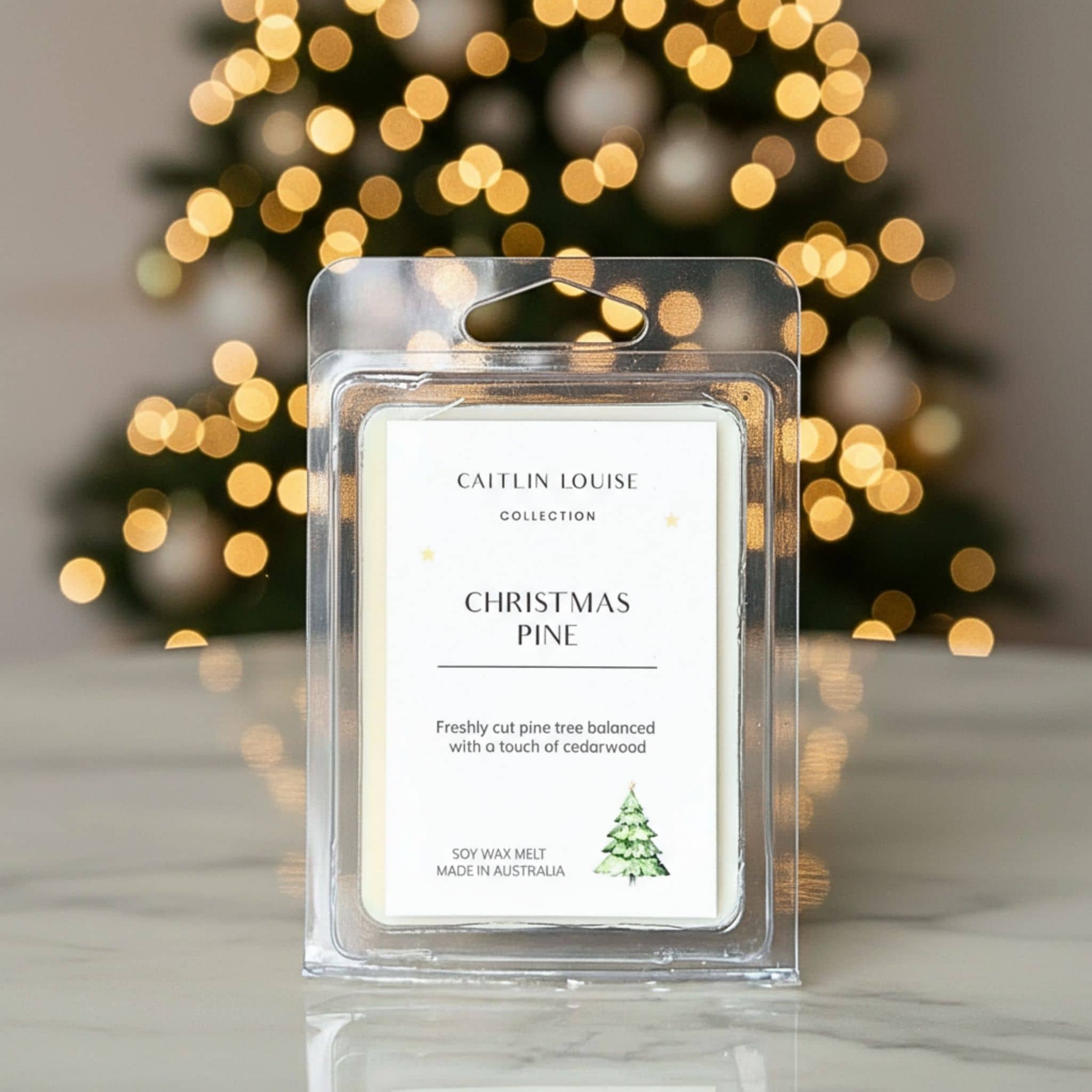 Caitlin Louise Collection Christmas Pine wax melt with blurred Christmas tree lights in the background