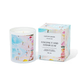 Caitlin Louise Collection Candle with beach-themed artwork and matching box on a white background