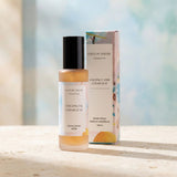 Room spray bottle with coconut and cedar leaf scent and packaging on a wooden surface.