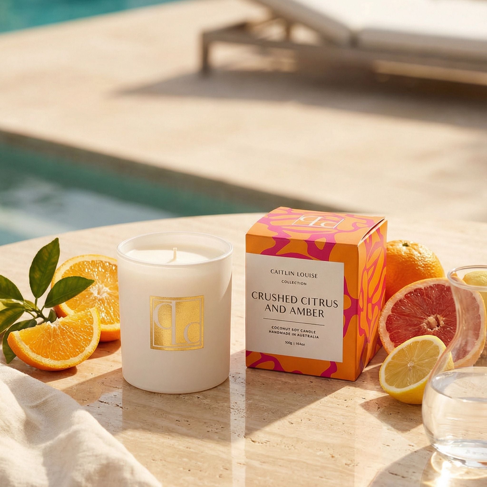 Candle and packaging with citrus fruits by a poolside