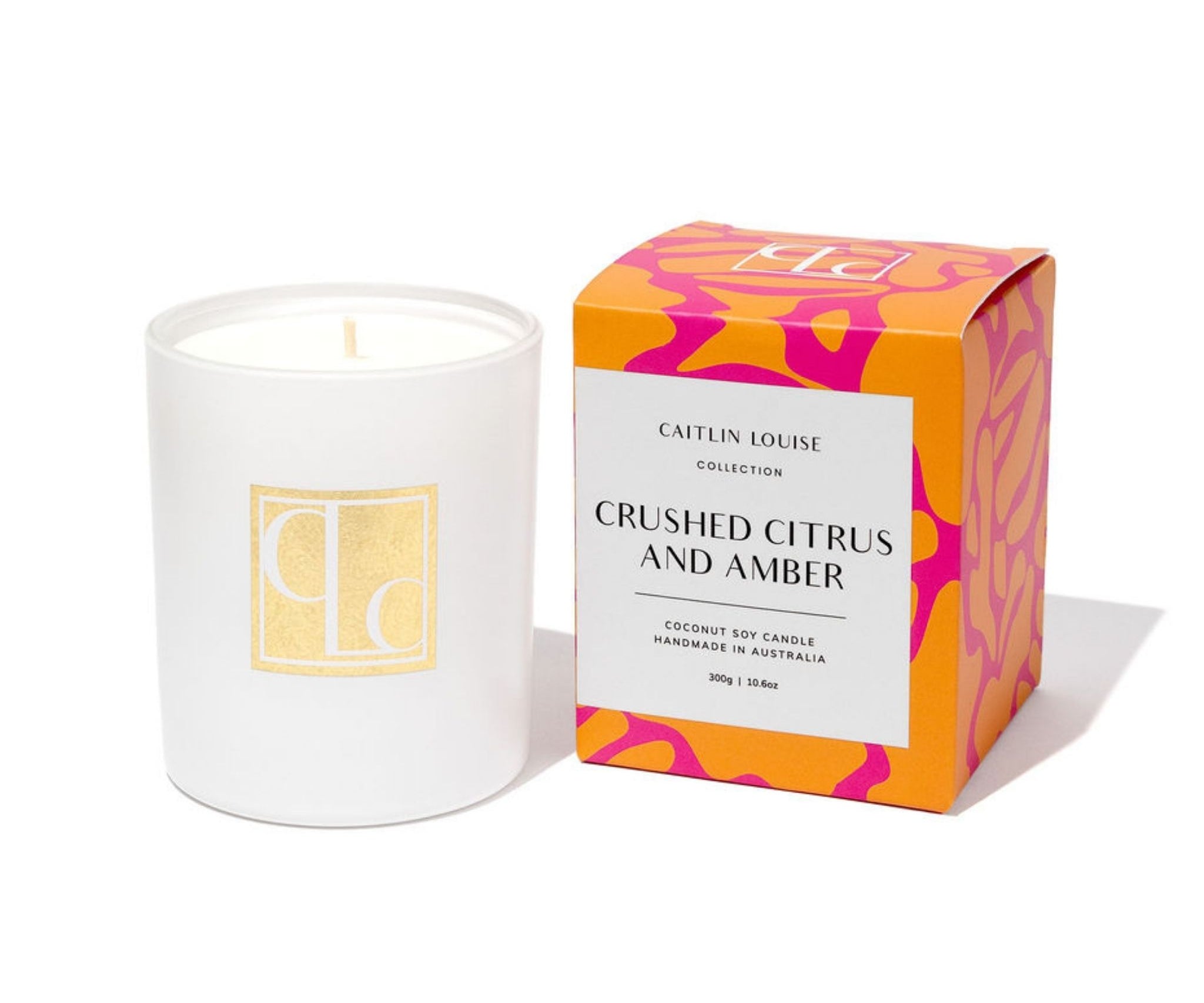 Candle with packaging labeled 'Crushed Citrus and Amber' by Caitlin Louise 
Collection on a white background