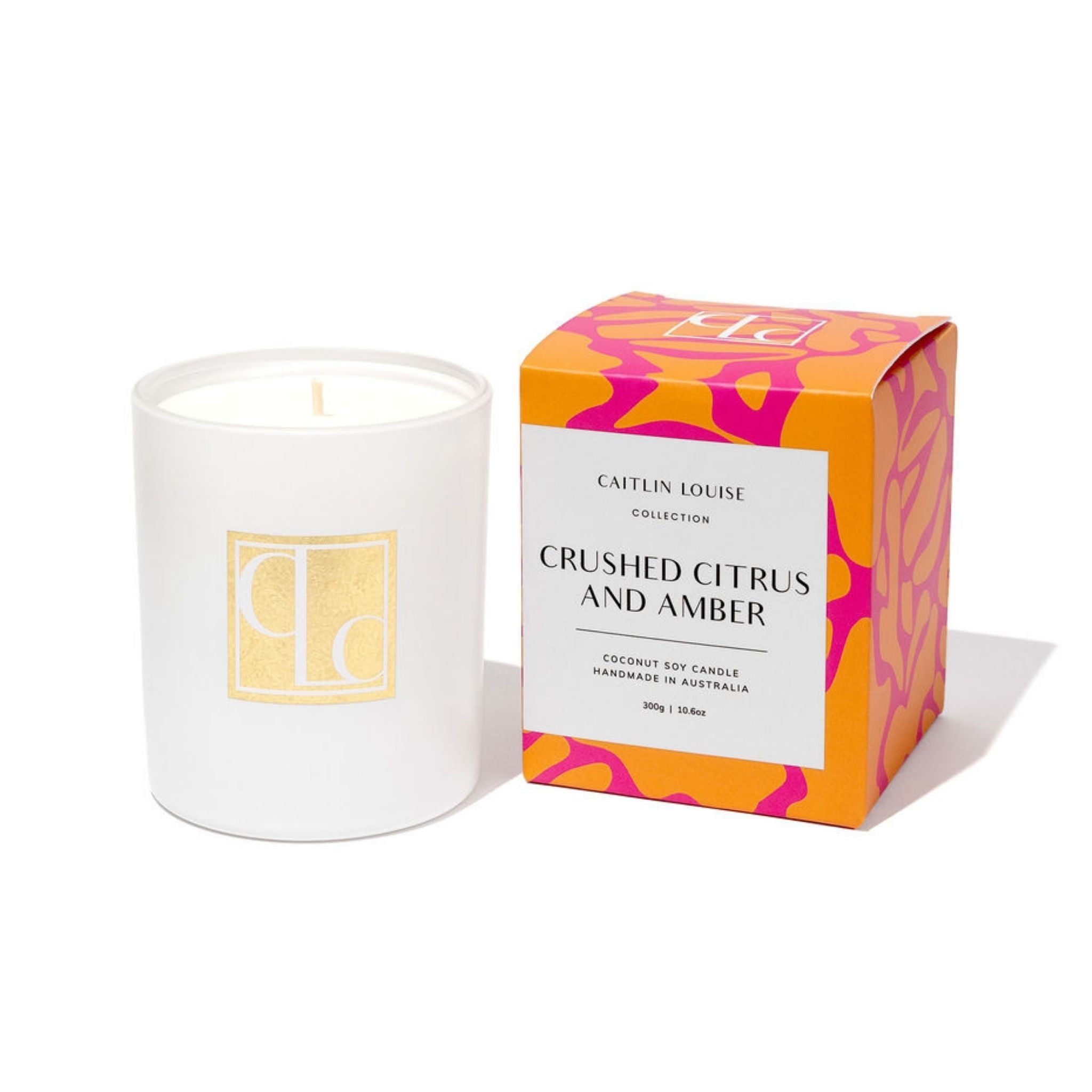 Candle with packaging labeled 'Crushed Citrus and Amber' by Caitlin Louise 
Collection on a white background