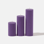 Dark purple Lumiere pillar candles in 3 sizes on white background