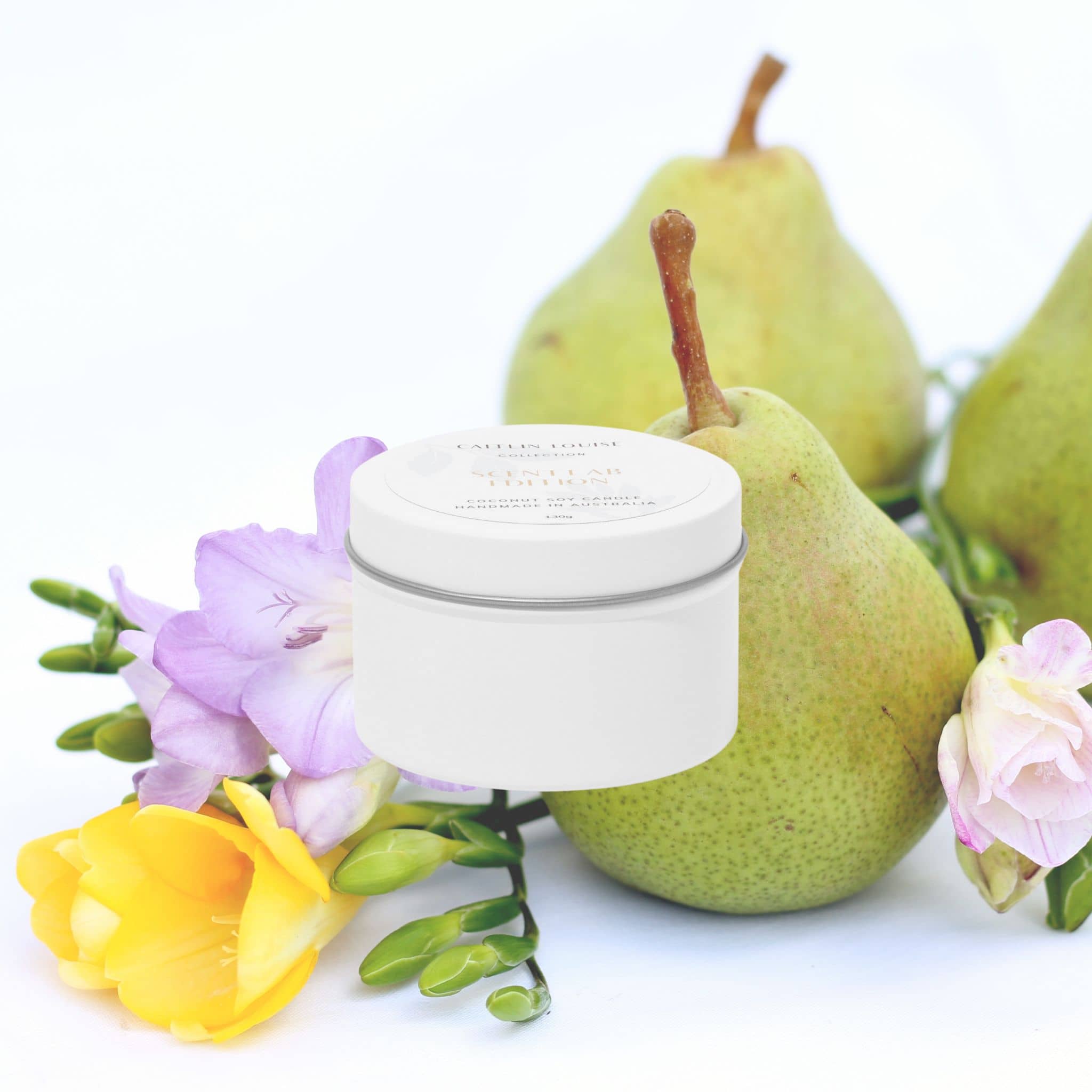 White travel tin candle with green pears, and flowers on a white background
