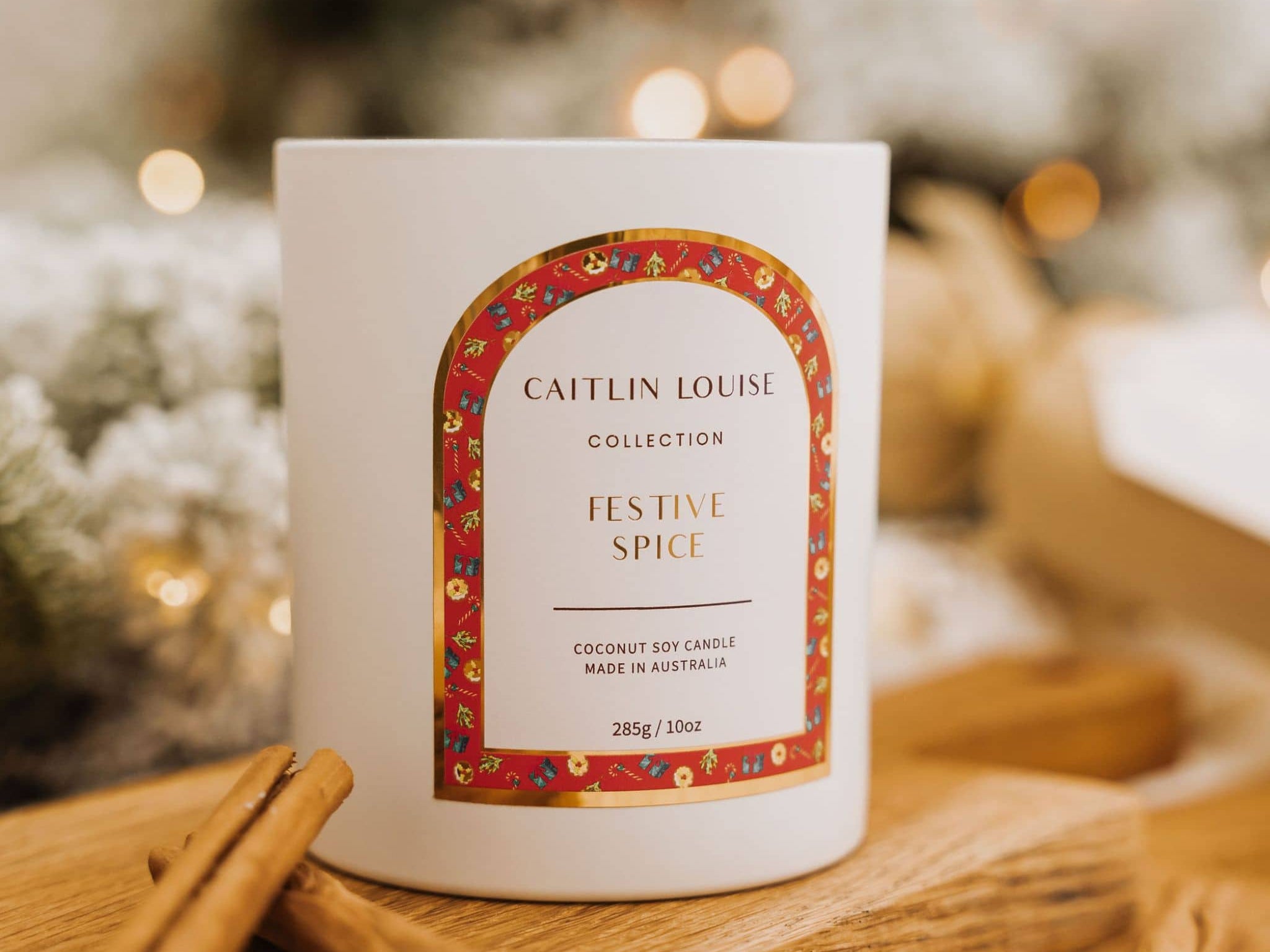 Caitlin Louise Collection Festive Spice Scented Christmas Candle - styled on brown board with cinnamon scrolls