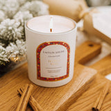 Caitlin Louise Collection Festive Spice Scented Christmas Candle styled with Christmas tree on brown board with cinnamon sticks