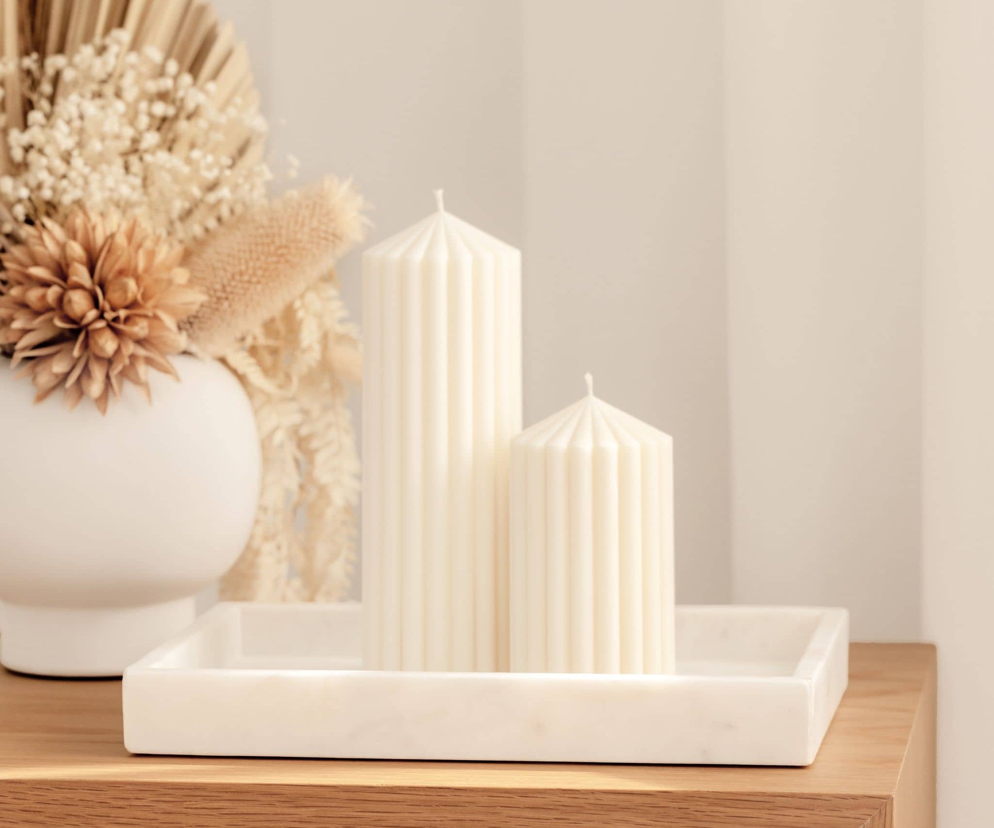 Harmonia pillar candles styled on sideboard with dried flower arrangement