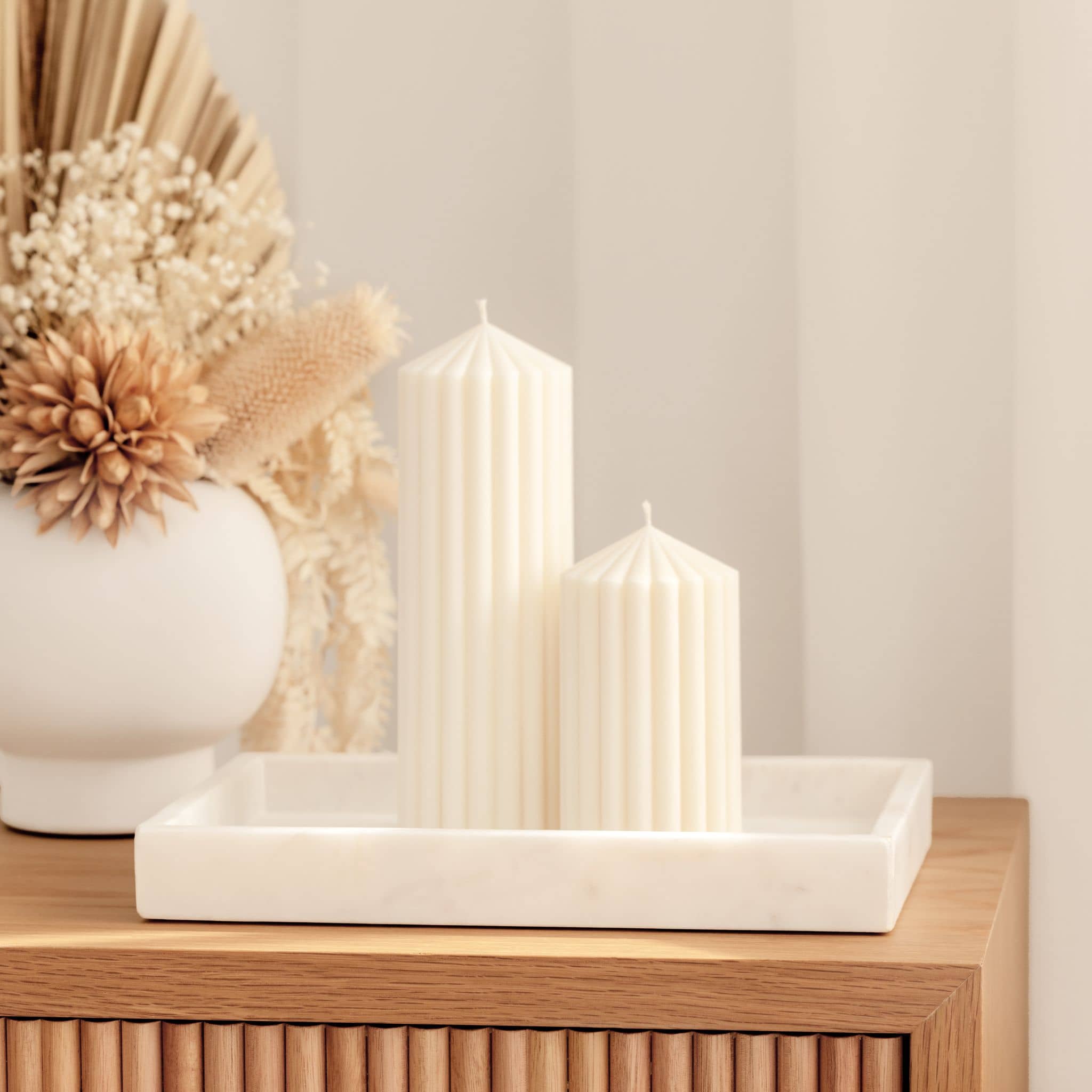 Harmonia pillar candles styled on sideboard with dried flower arrangement
